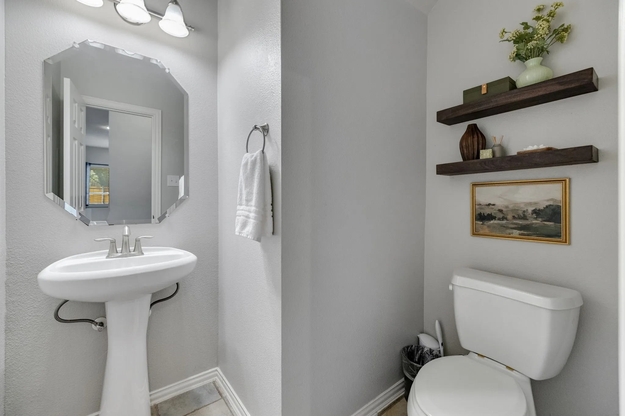 Great downstairs powder bathroom perfect for guests.  Charming floating wood shelves too!