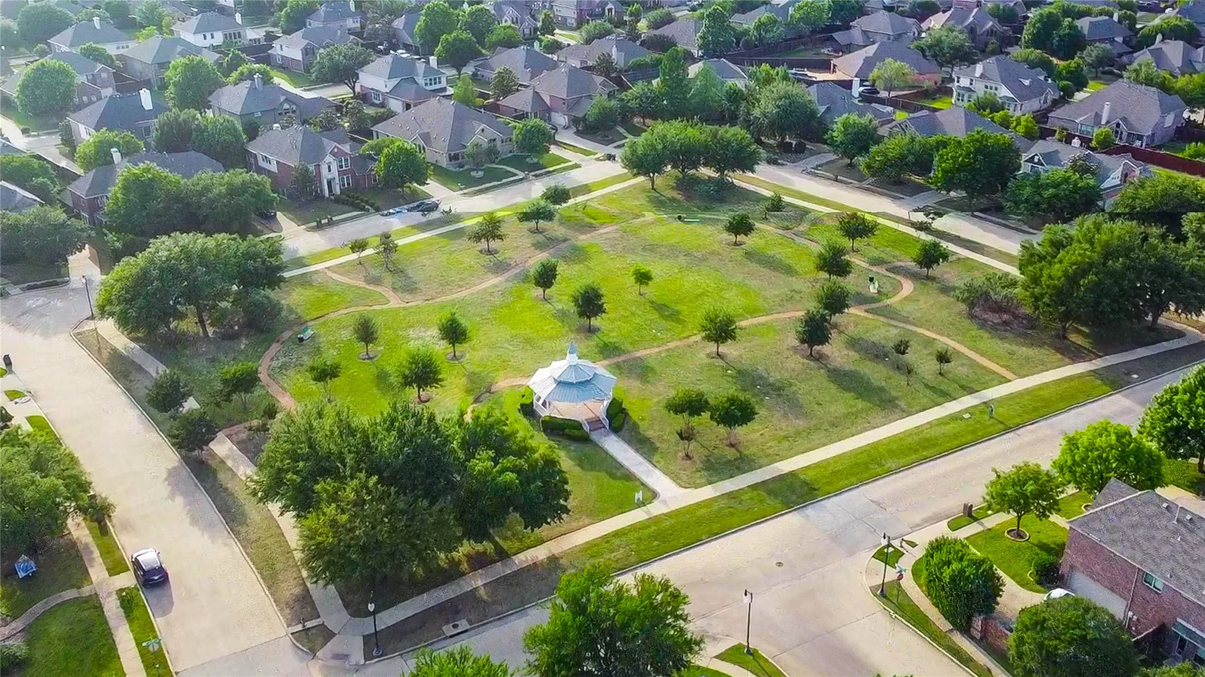 The neighborhood offers so many expansive green spaces like this one featuring a gazebo, walking paths, and mature trees.