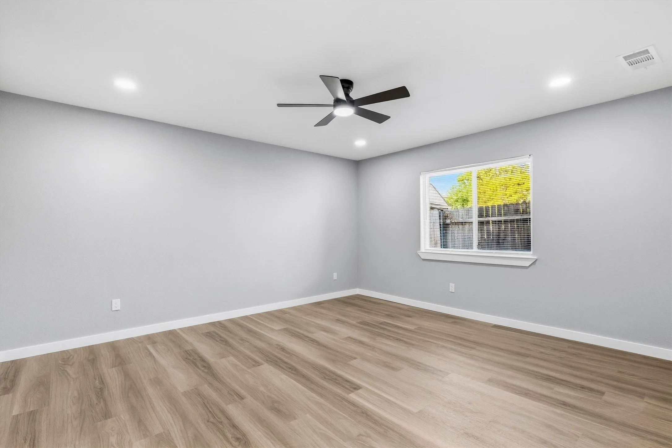 Wood-finish flooring, recessed lighting, ceiling fan, and a double-pane window