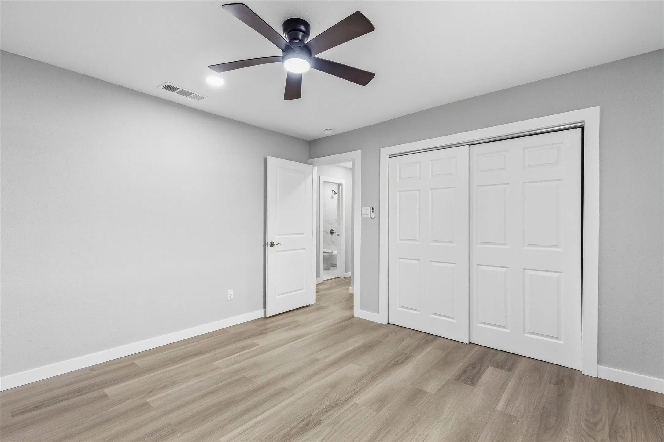 Wood-finish flooring, recessed lighting, and a dark-toned ceiling fan