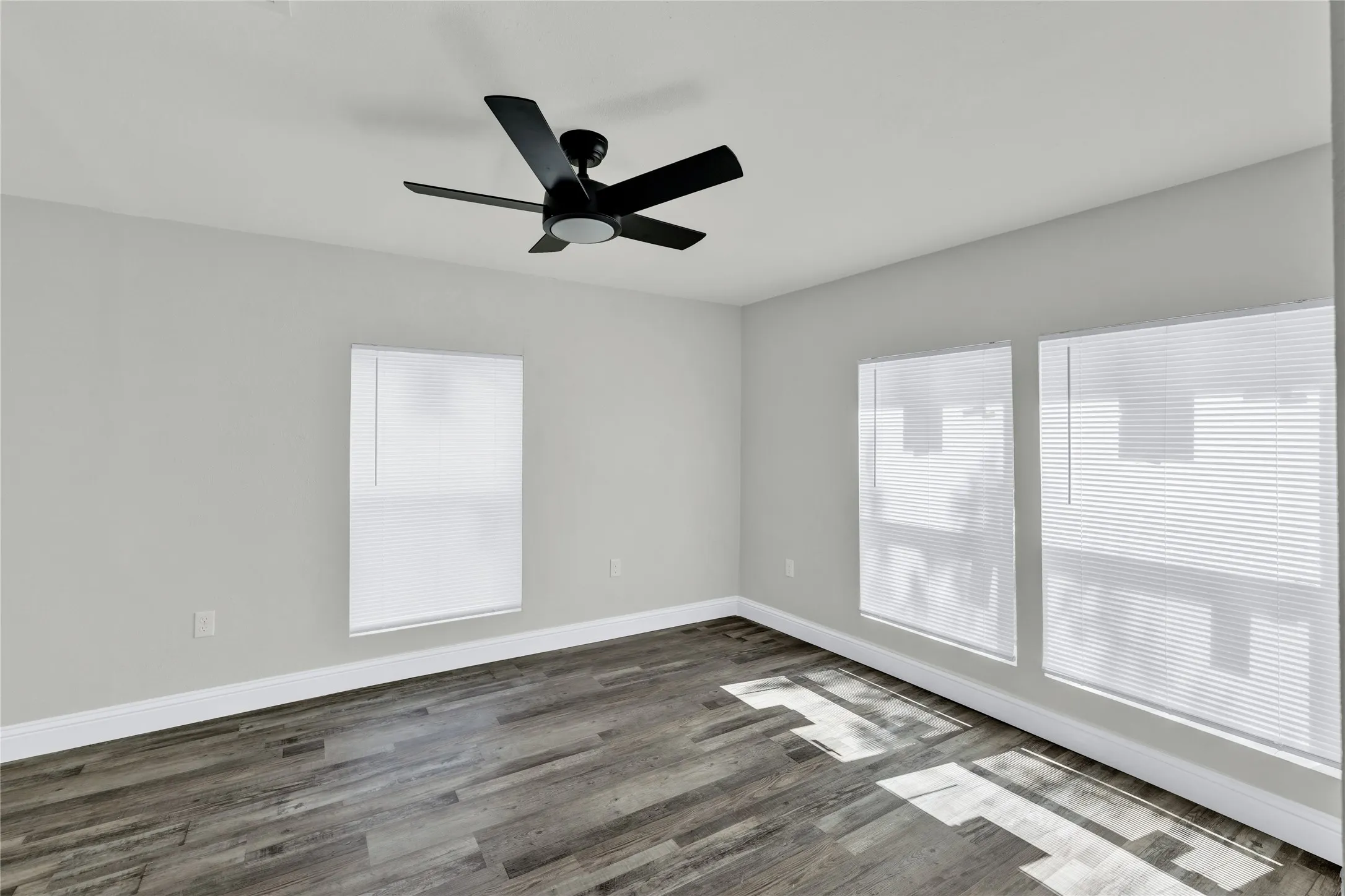 Ceiling fan, wood-finish flooring, light gray wall color, white window blinds, white trim