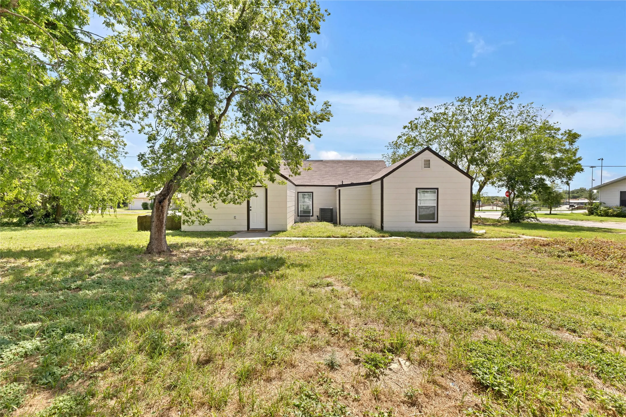 Expansive grassed yard with mature trees providing shade