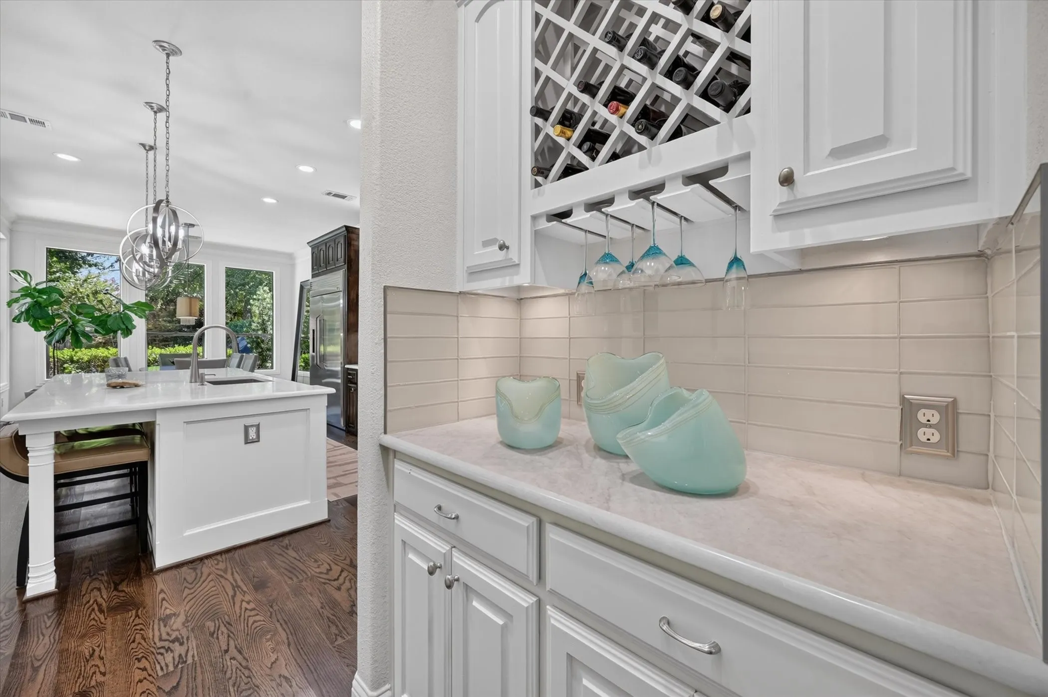 White cabinetry with a built-in wine rack and glass storage