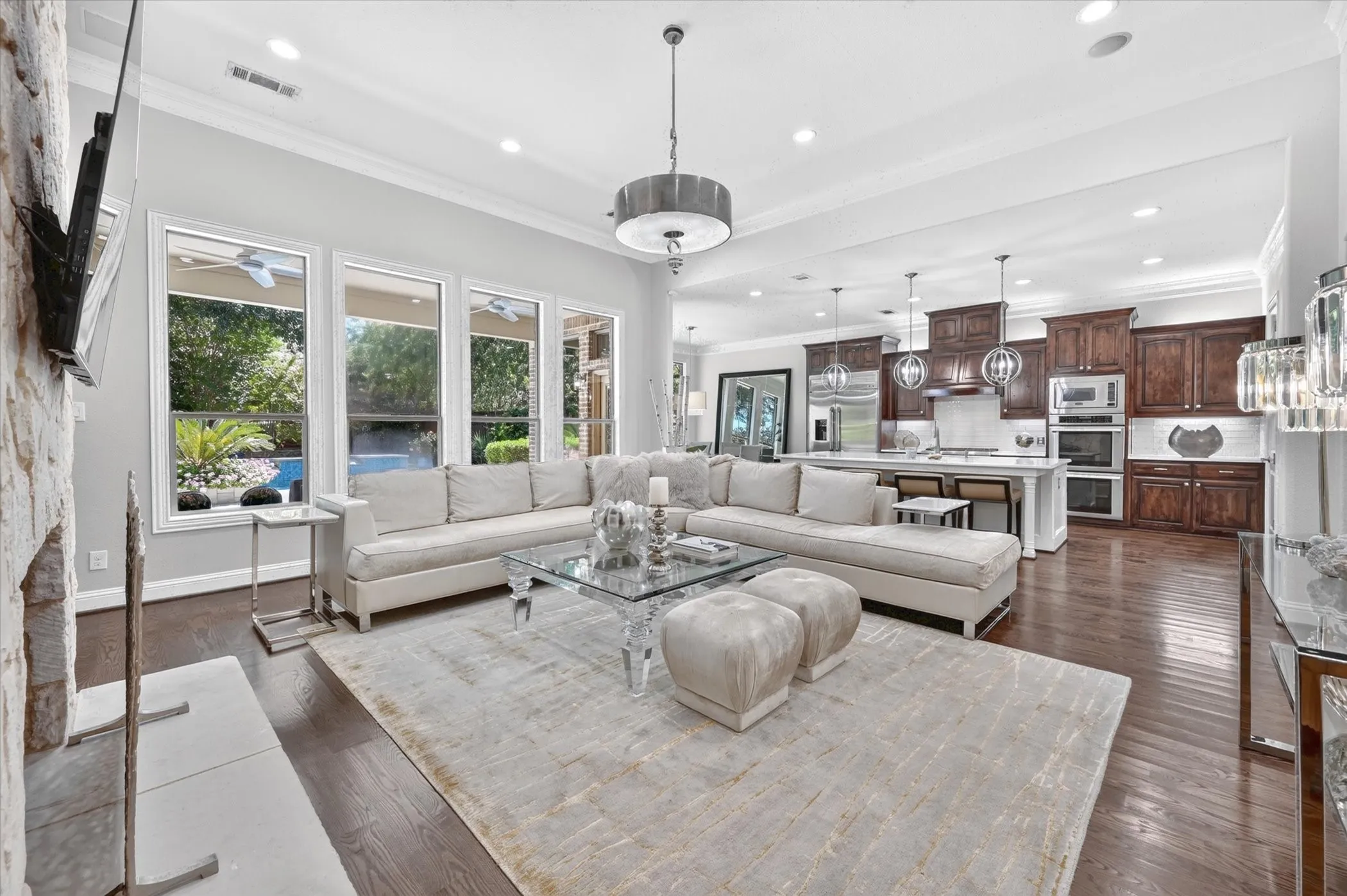 Hardwood flooring throughout, custom cabinetry, recessed lighting, and a stone-clad fireplace