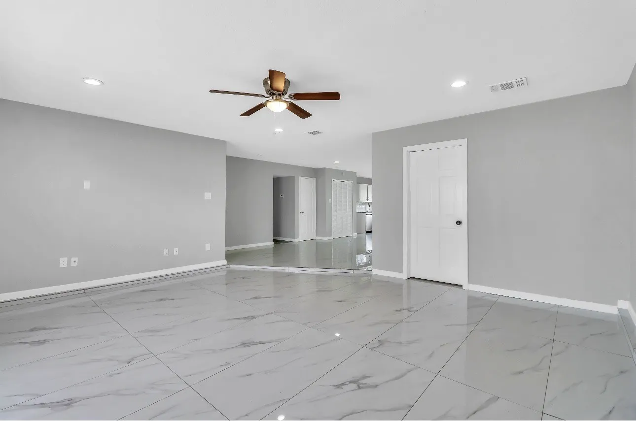 Spacious interior dining area room featuring large format tile flooring, light gray wall paint, recessed lighting, a ceiling fan, and white trim throughout