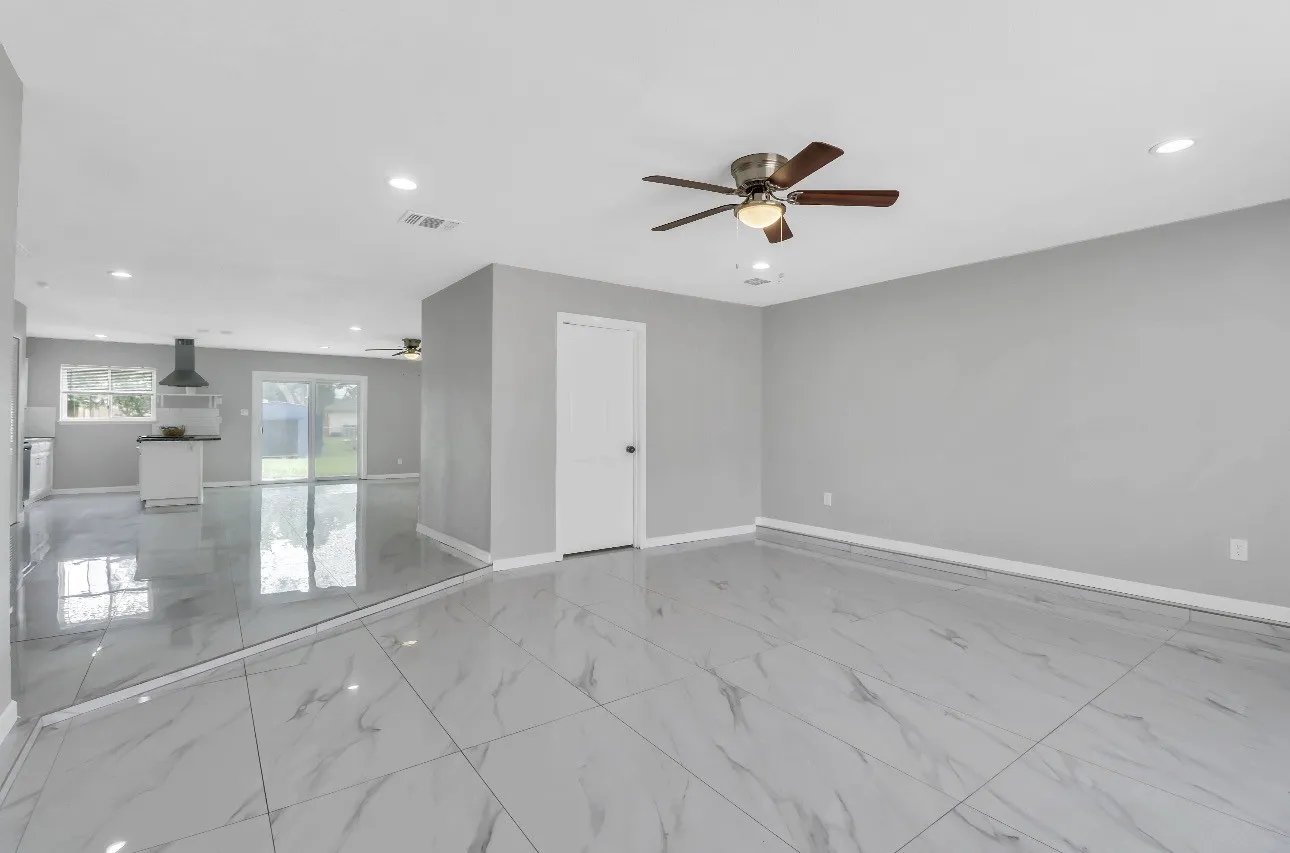 Spacious second family room featuring large format marble-look tile flooring, recessed lighting, and a ceiling fan