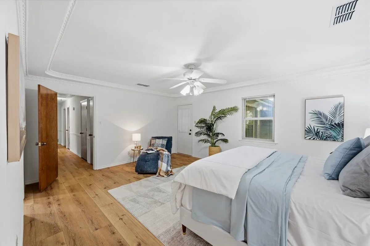 Wood-finish flooring, white walls, and a ceiling fan with light fixture