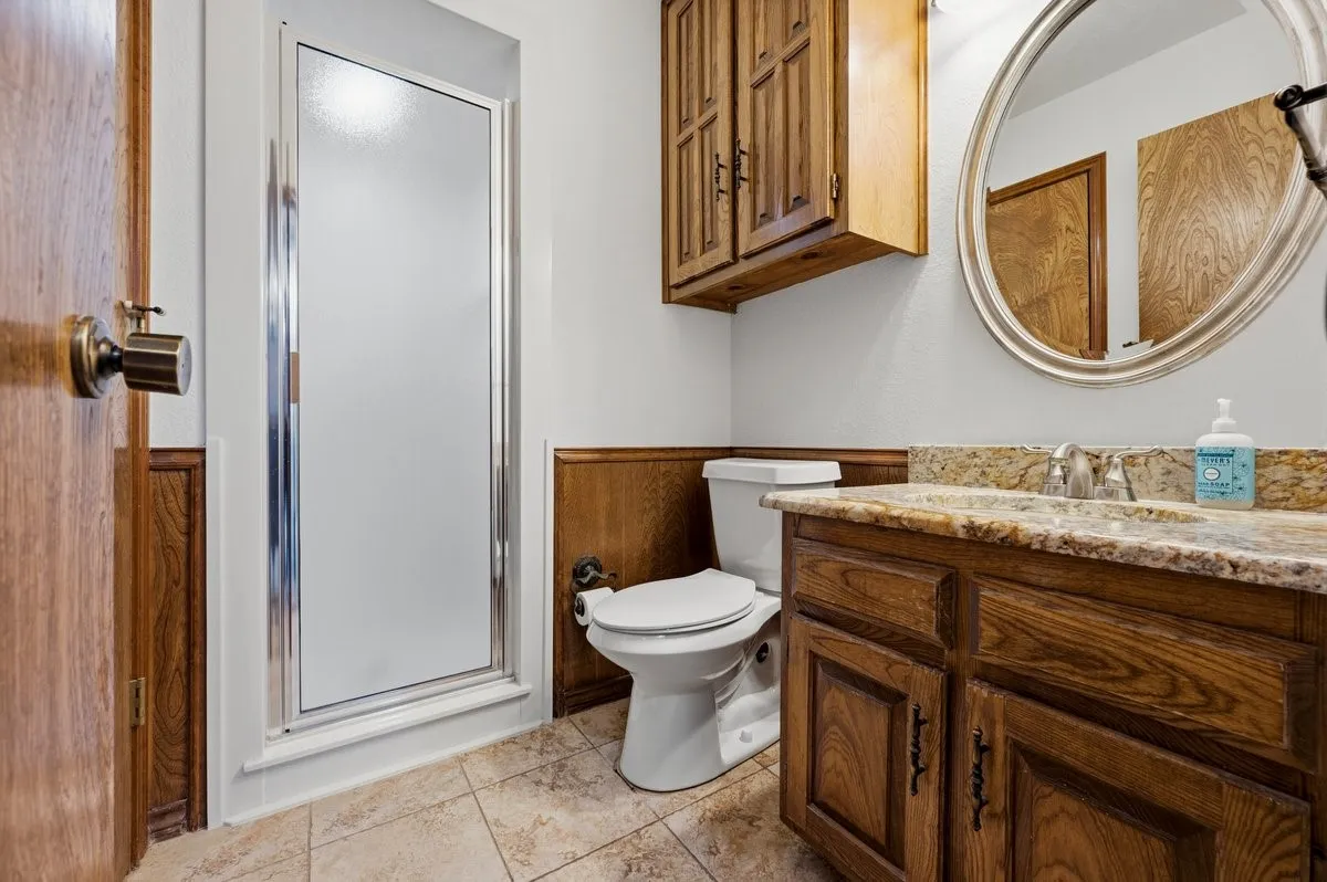 Wood-finish vanity with an integrated sink and stone-finish countertop
