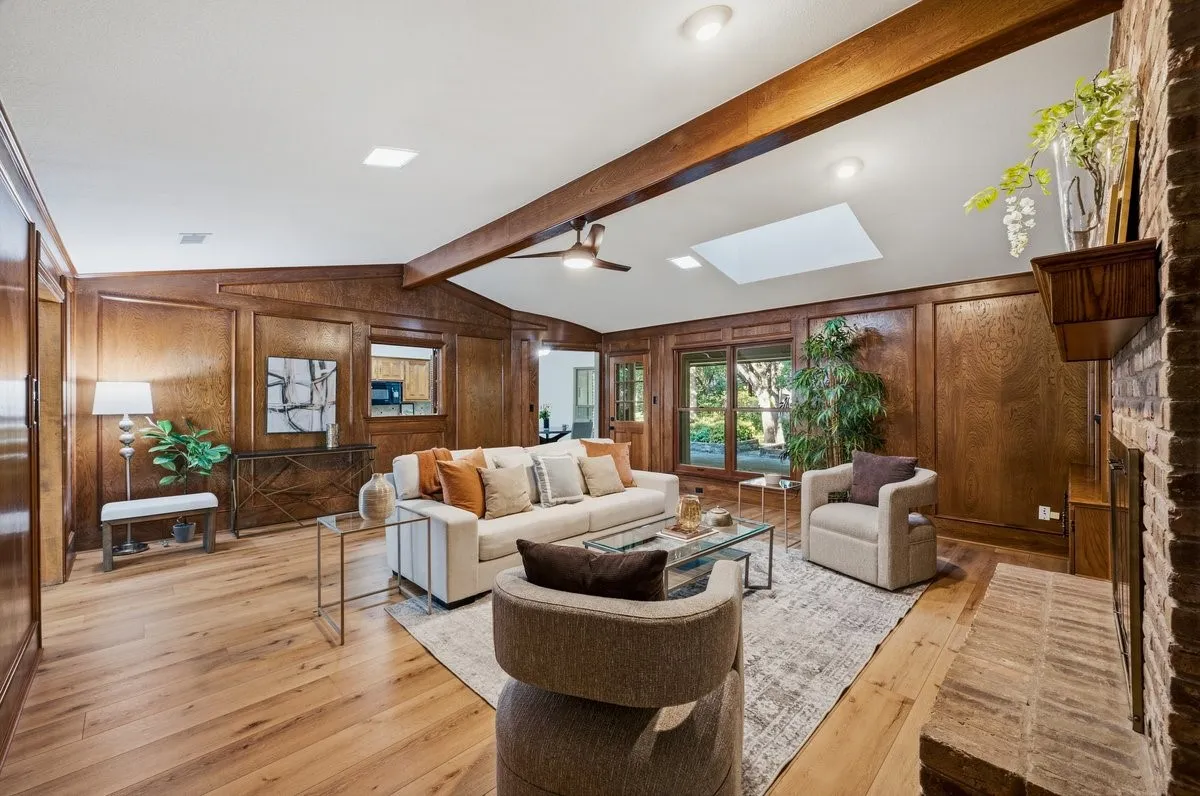 Wood-finish flooring with recessed lighting, exposed ceiling beams, and a skylight
