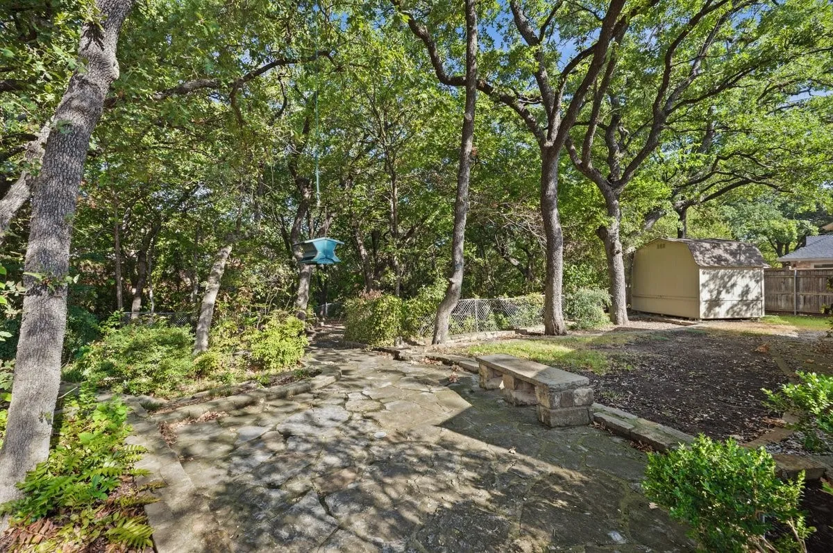 Outdoor hardscaping with a stone patio and built-in stone bench