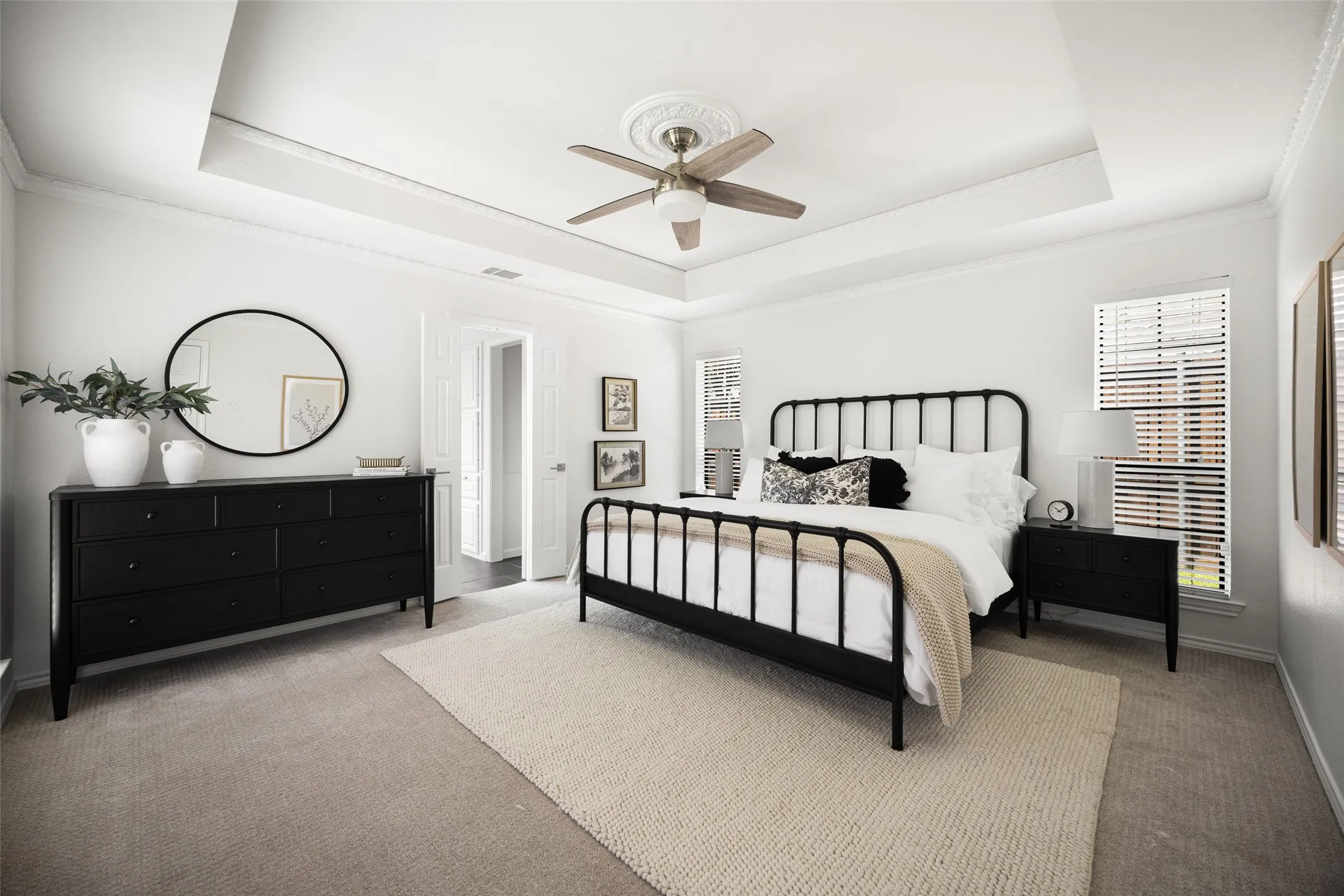 Spacious primary with ceiling fan and carpet flooring