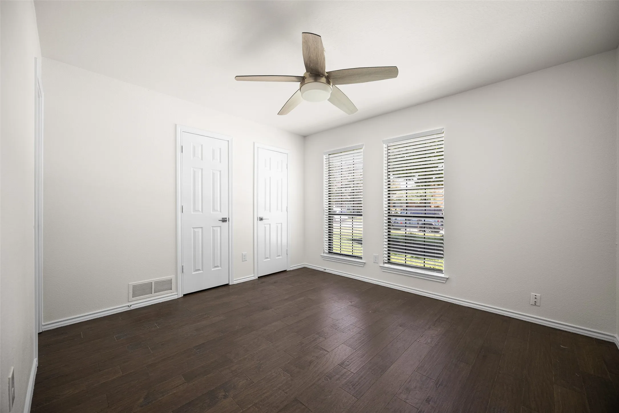 Bedroom with ceiling fan and hardwood flooring