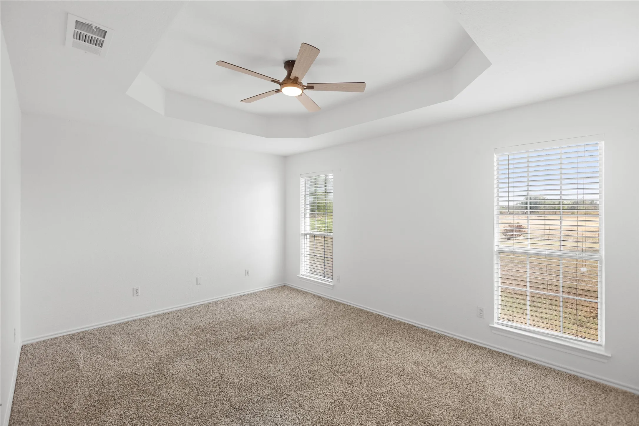 Fresh paint, plush carpet, abundant natural light, and a beautiful tray ceiling create a peaceful space to unwind.