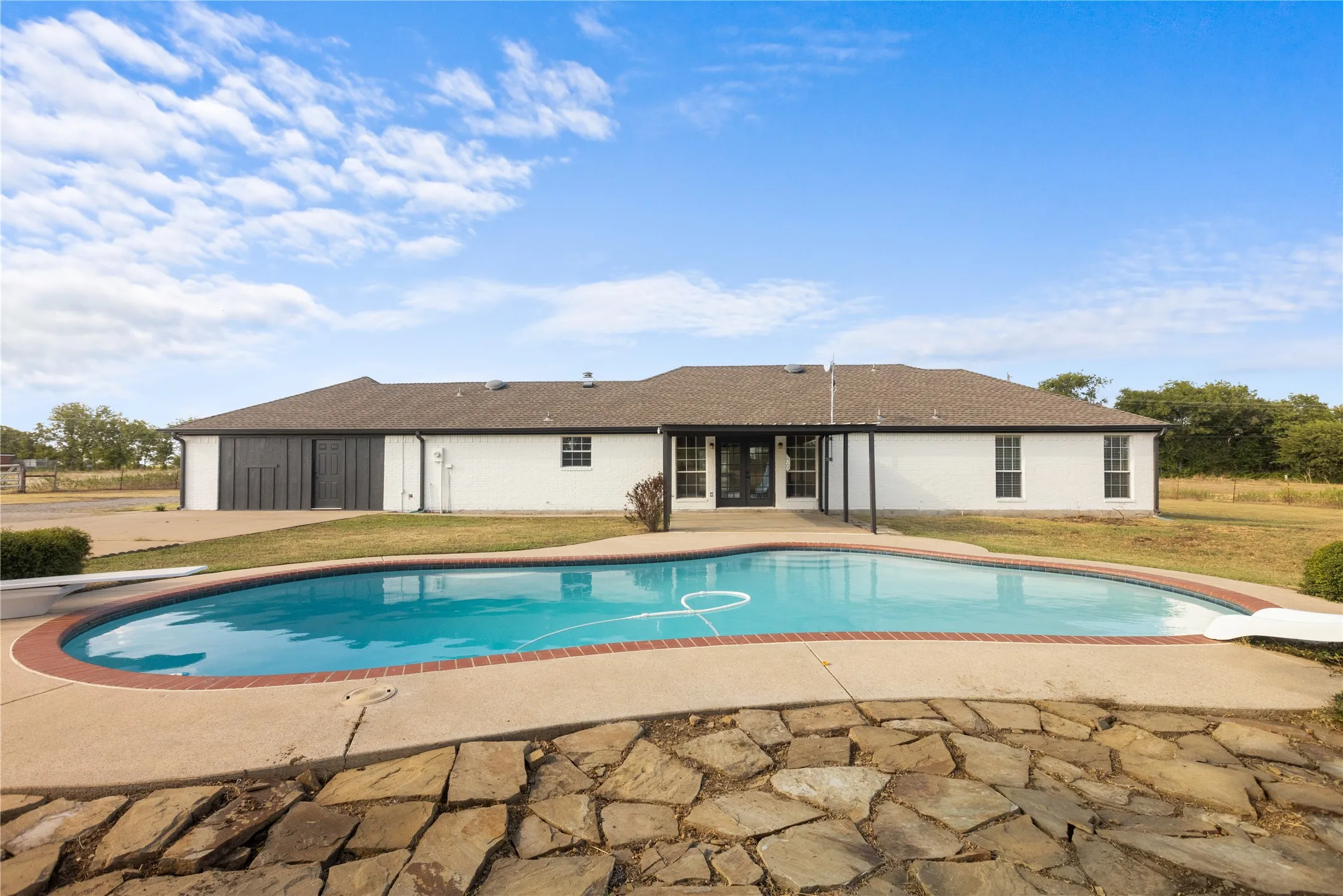 Plenty of space surrounds the pool for lounging, gathering, dining, and enjoying long summer days with family and friends.