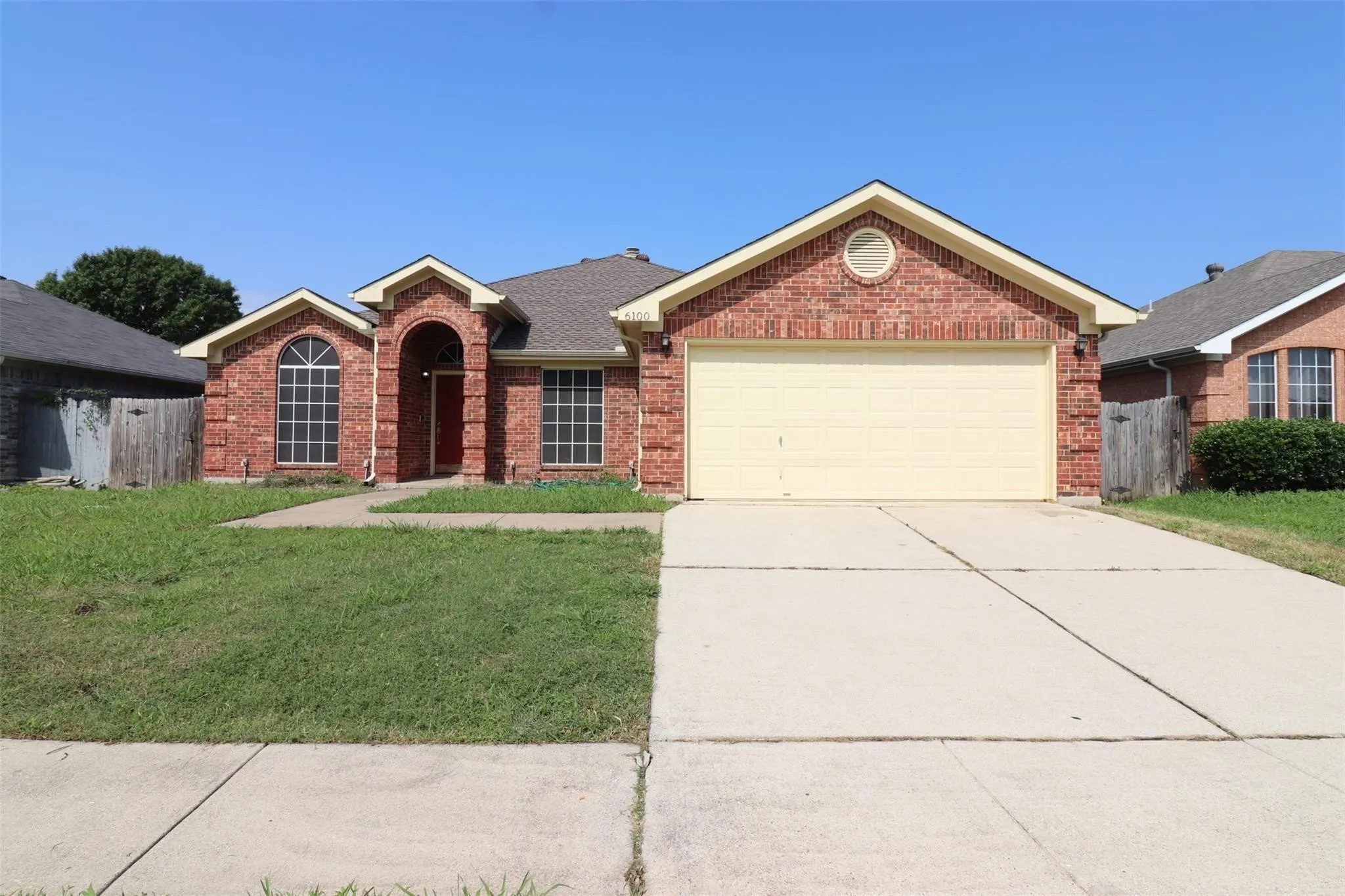 Brick exterior, arched entry, arched window, two-car garage, concrete driveway