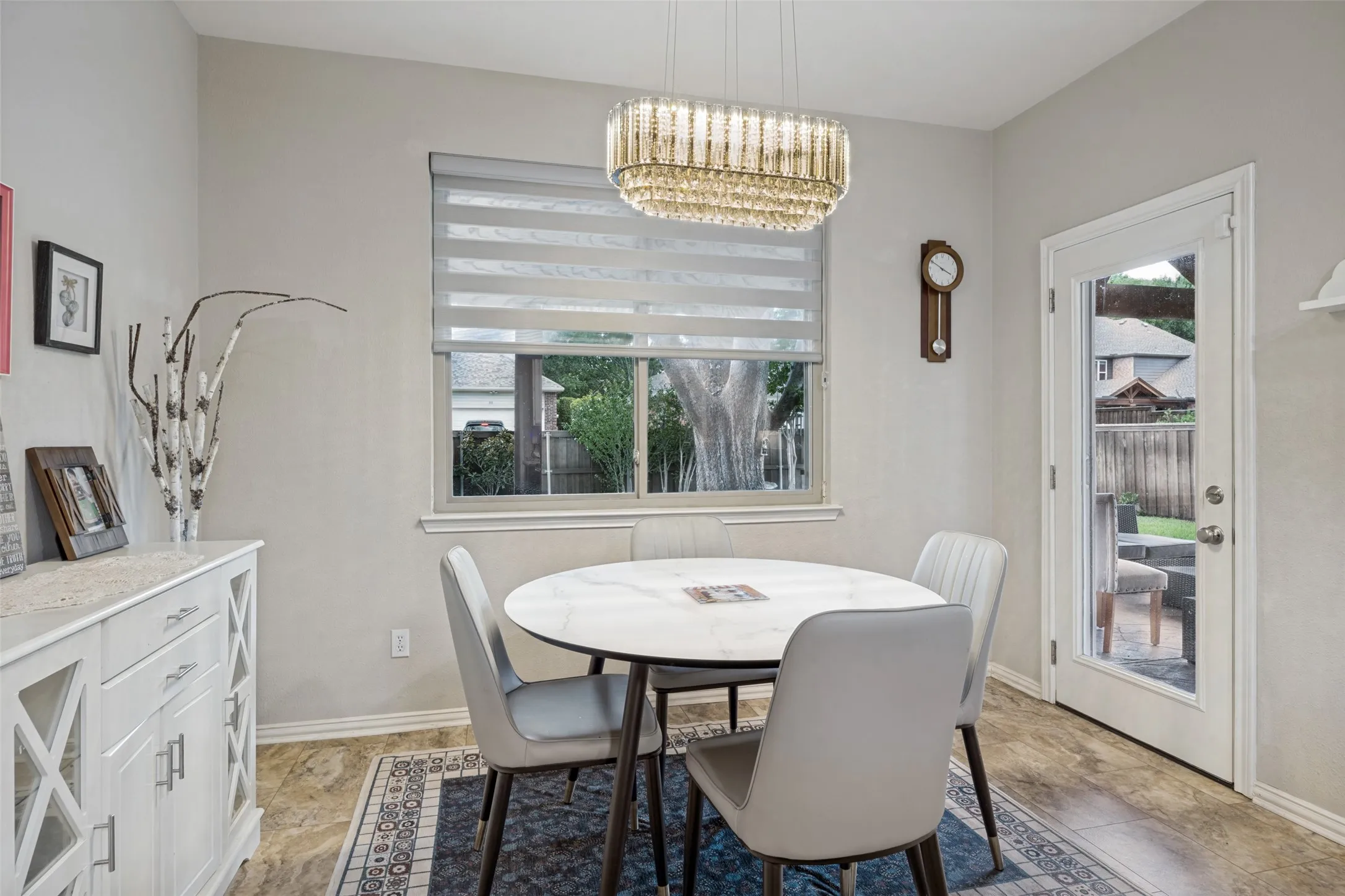 Recessed lighting with a contemporary chandelier, large window with blinds, wood-finish flooring, and a glass-paneled door
