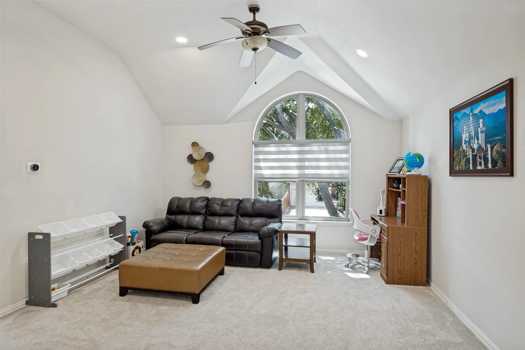 Vaulted ceiling with a ceiling fan, arched window with horizontal blinds, recessed lighting, and light-toned carpeting