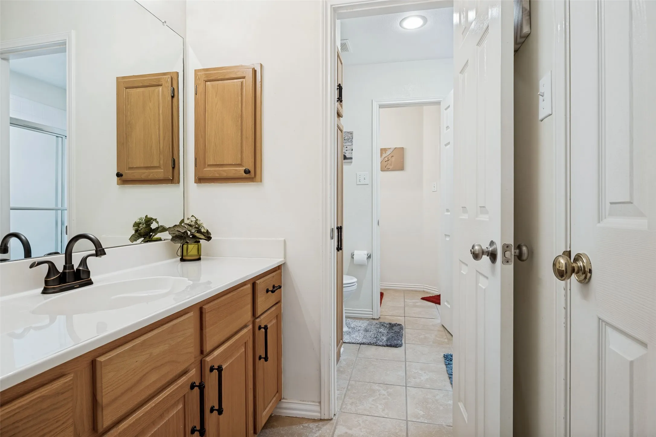 Vanity with wood cabinetry, integrated sink, and bronze-finish faucet