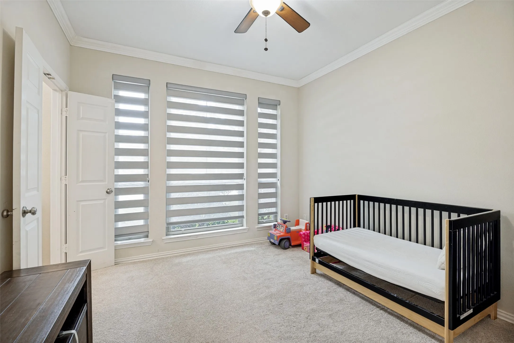 Recessed lighting, crown molding, ceiling fan, carpet flooring, and multiple windows with custom blinds