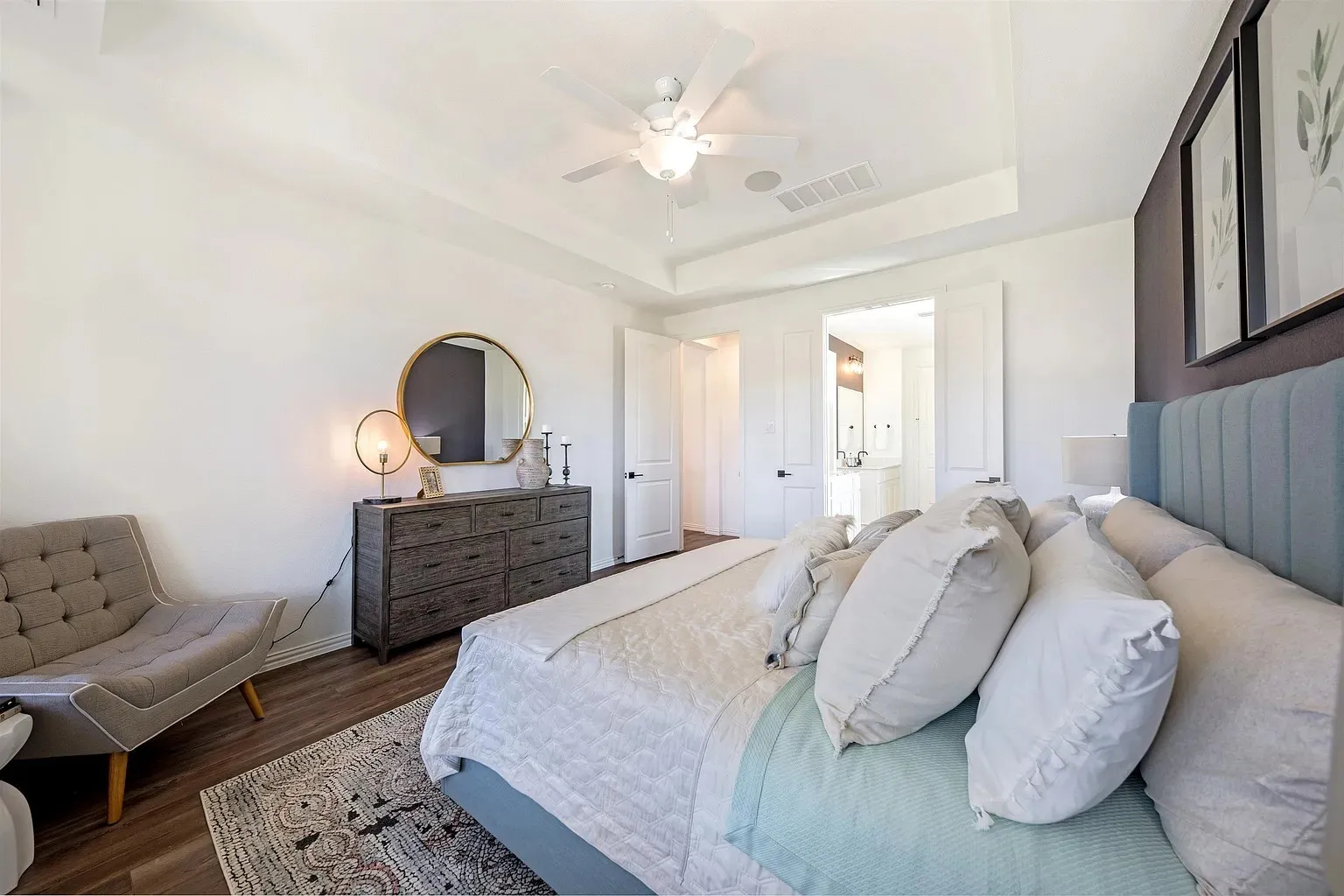 Tray ceiling with a ceiling fan, wood-finish flooring, and white paneled doors