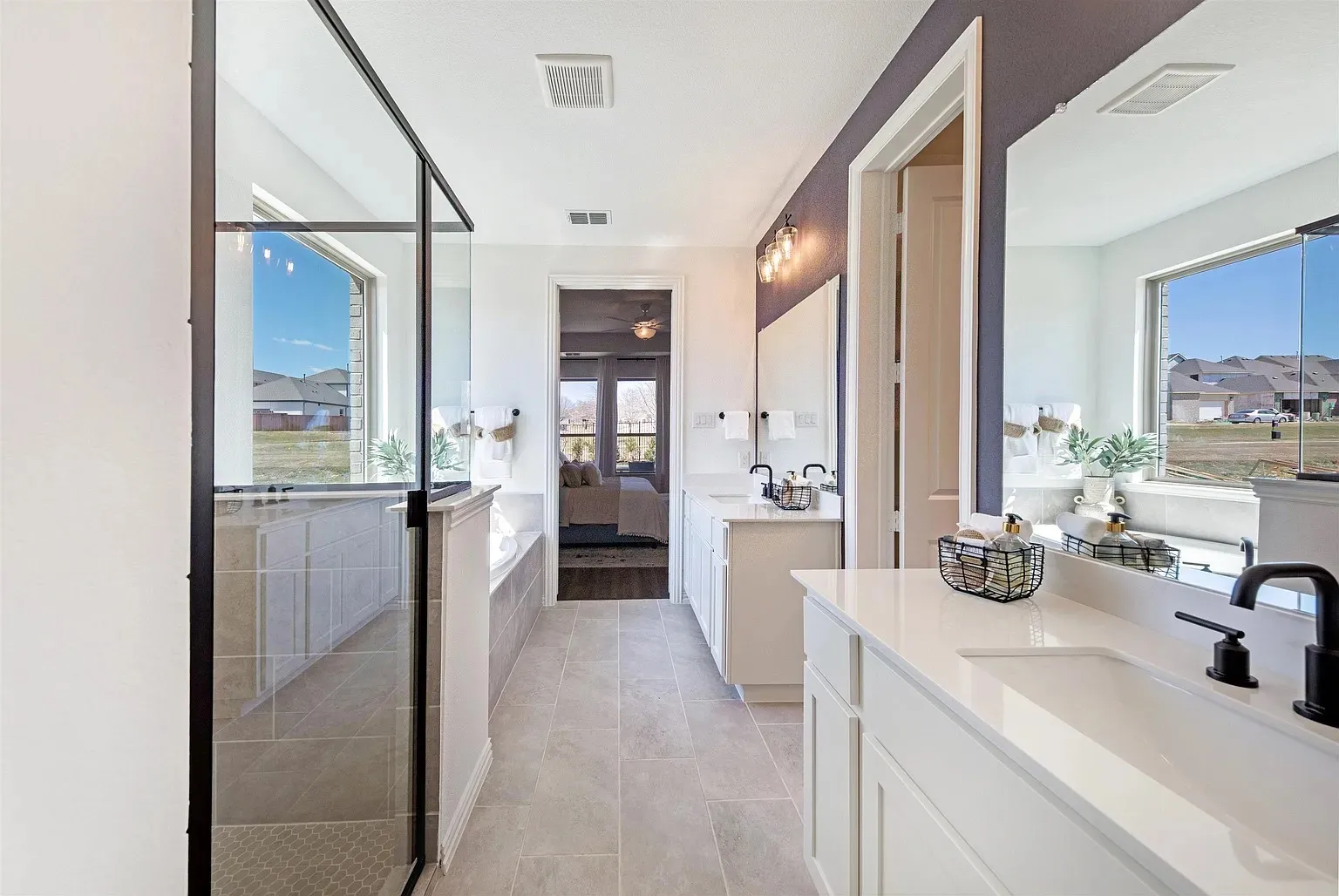 Dual vanities with white countertops, matte black fixtures, and framed mirrors