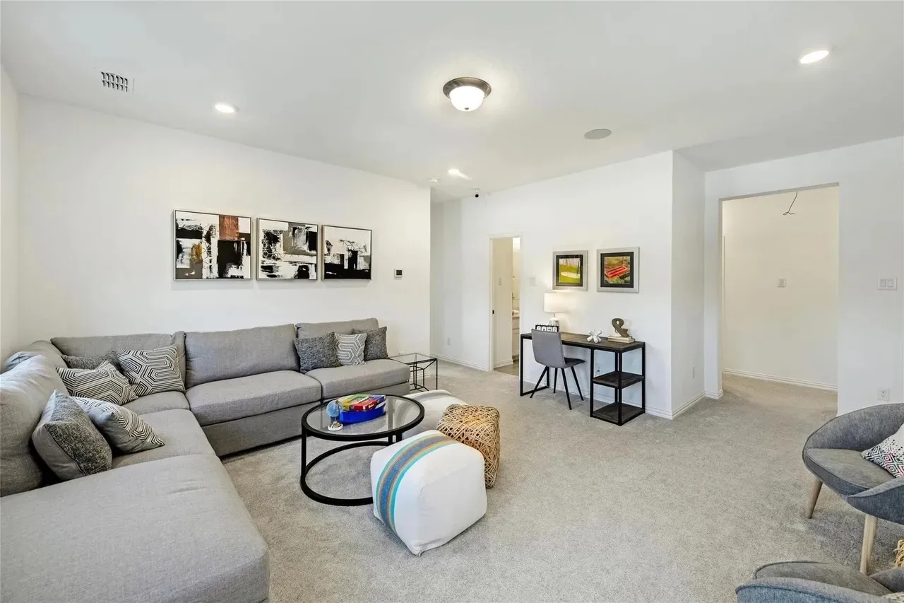 Recessed ceiling lighting, flush mount ceiling fixture, light-toned carpeting, white wall finishes, and a built-in desk area