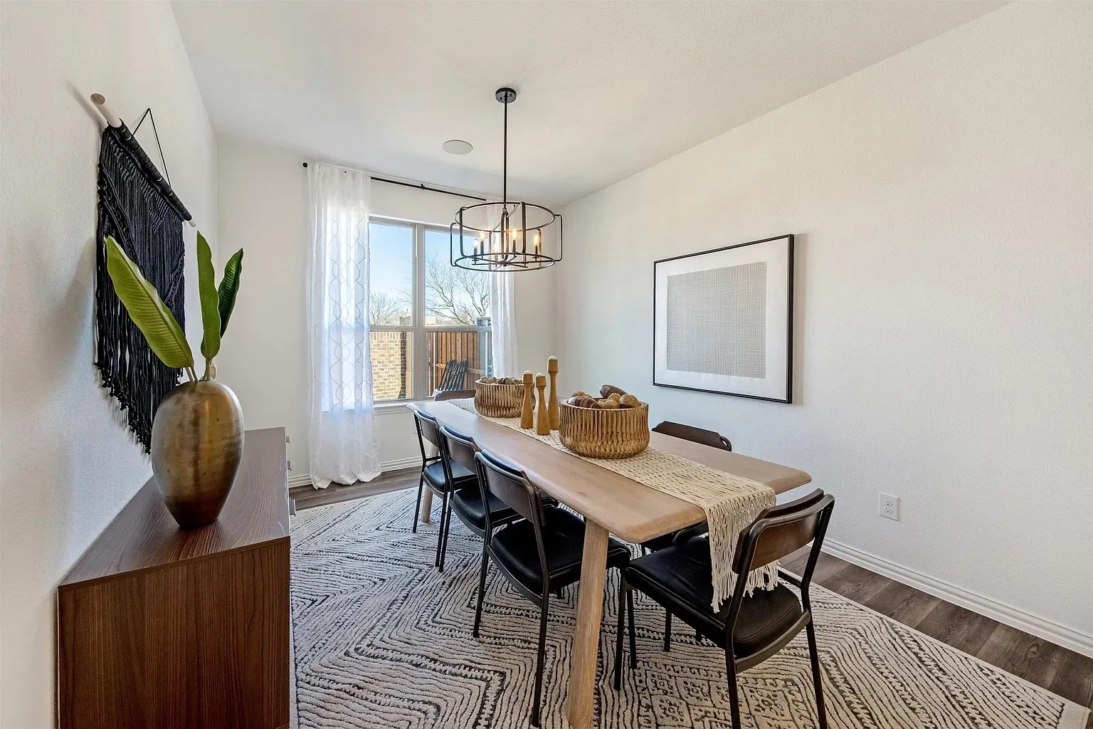 Open concept dining area with wood-finish flooring and a contemporary chandelier