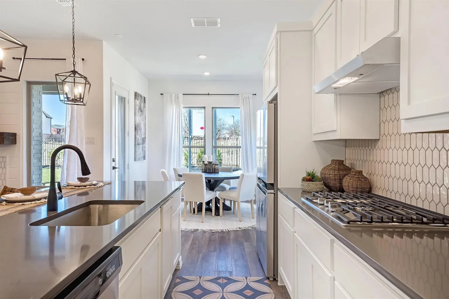 Kitchen featuring white cabinetry, dark countertops, a gas cooktop, and a stainless steel refrigerator