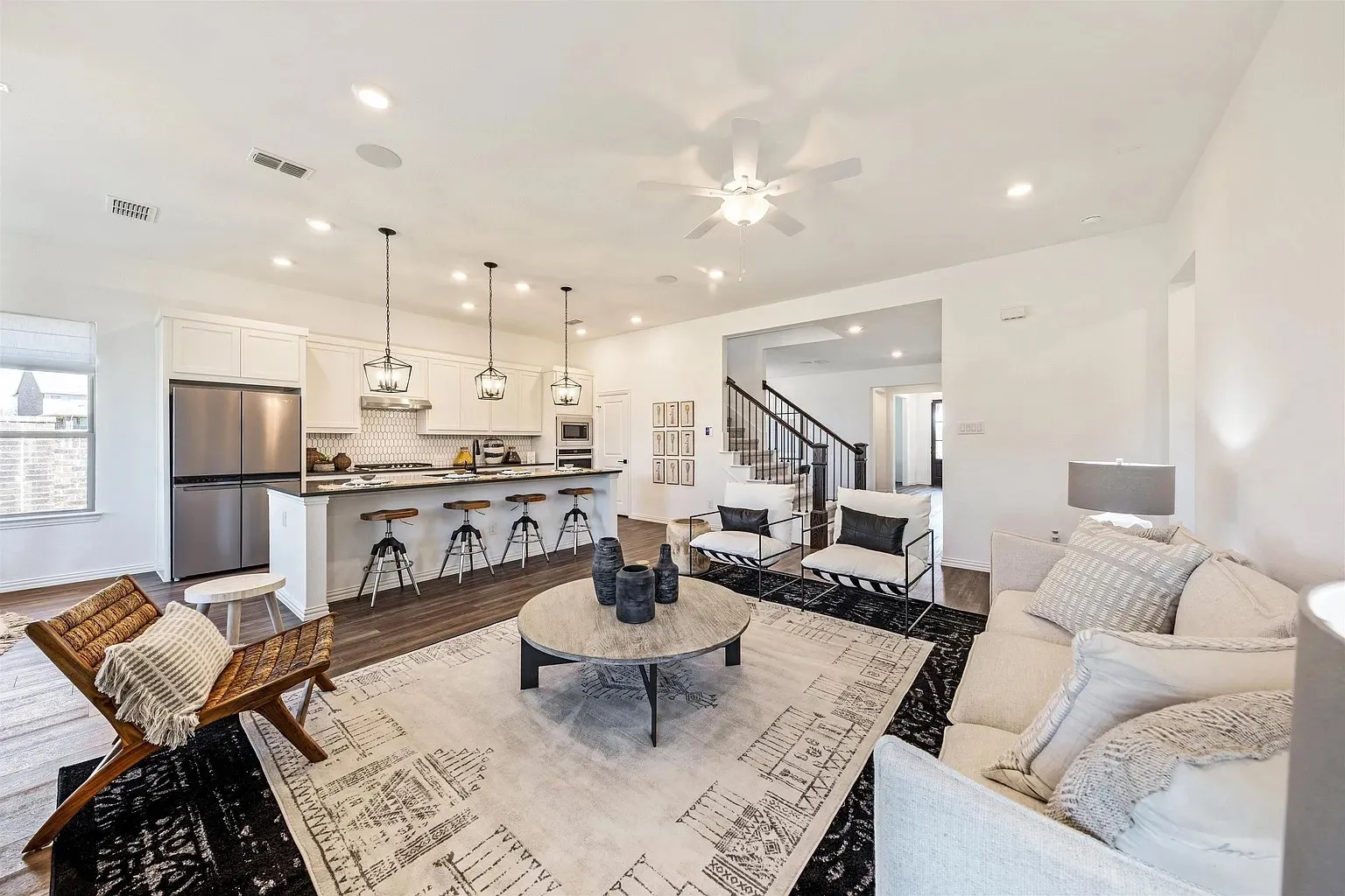 Open-concept living area with wood-finish flooring, recessed lighting, and a ceiling fan