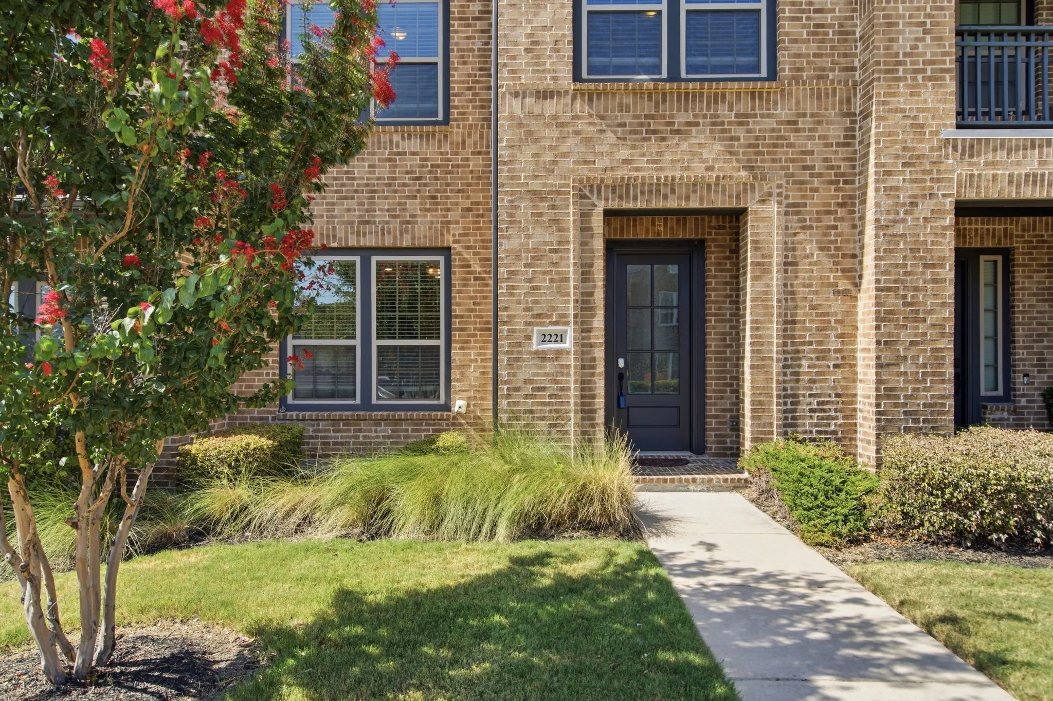 Brick facade with dark-framed windows and a complementary dark entry door