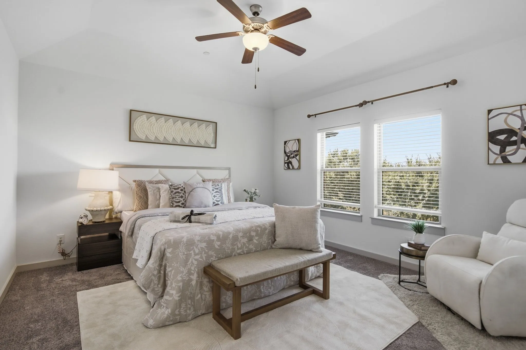 Bright bedroom featuring a vaulted ceiling and a ceiling fan with integrated lighting