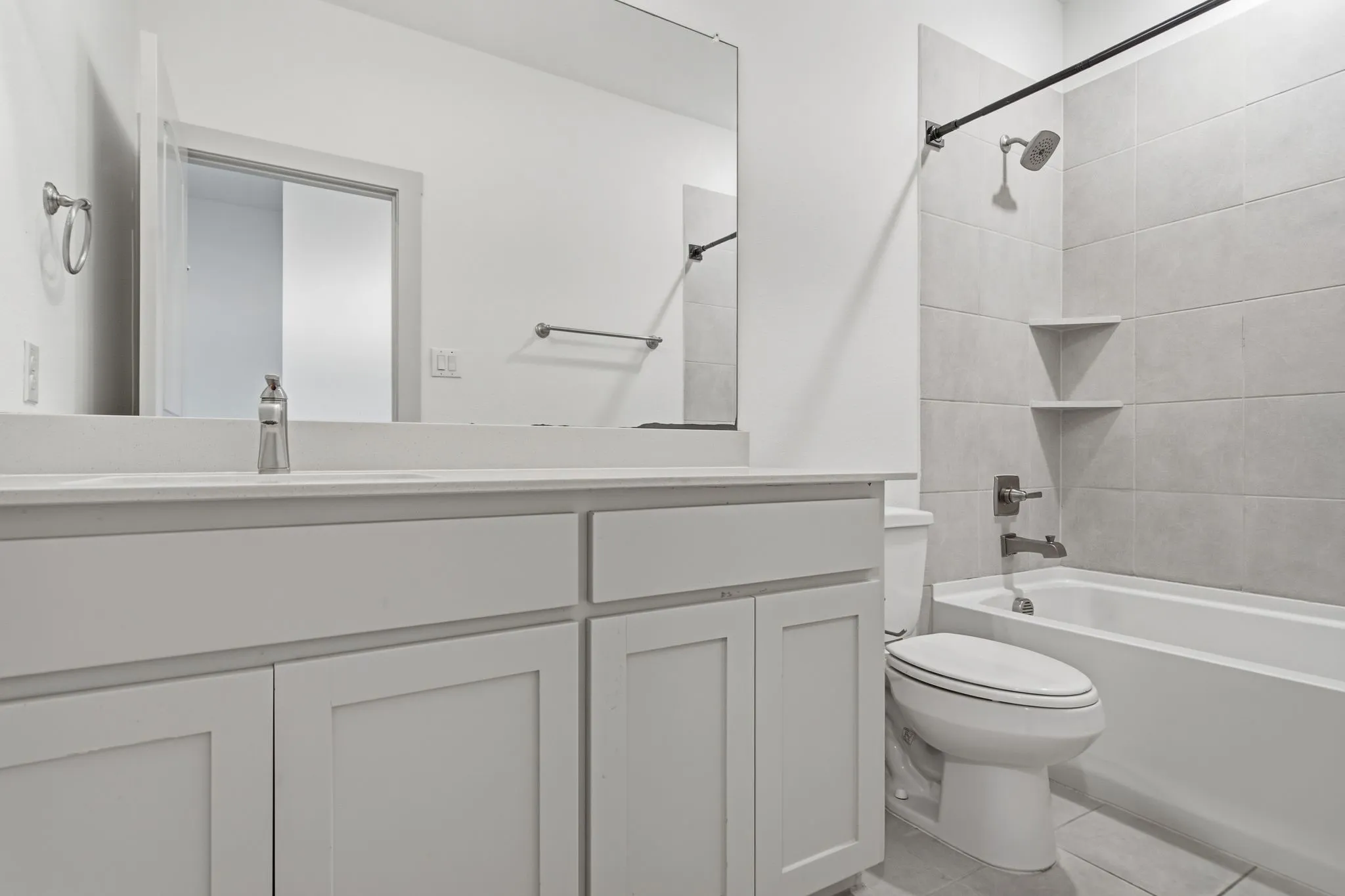 Bathroom featuring a single vanity with a light countertop, white cabinetry, and a rectangular mirror