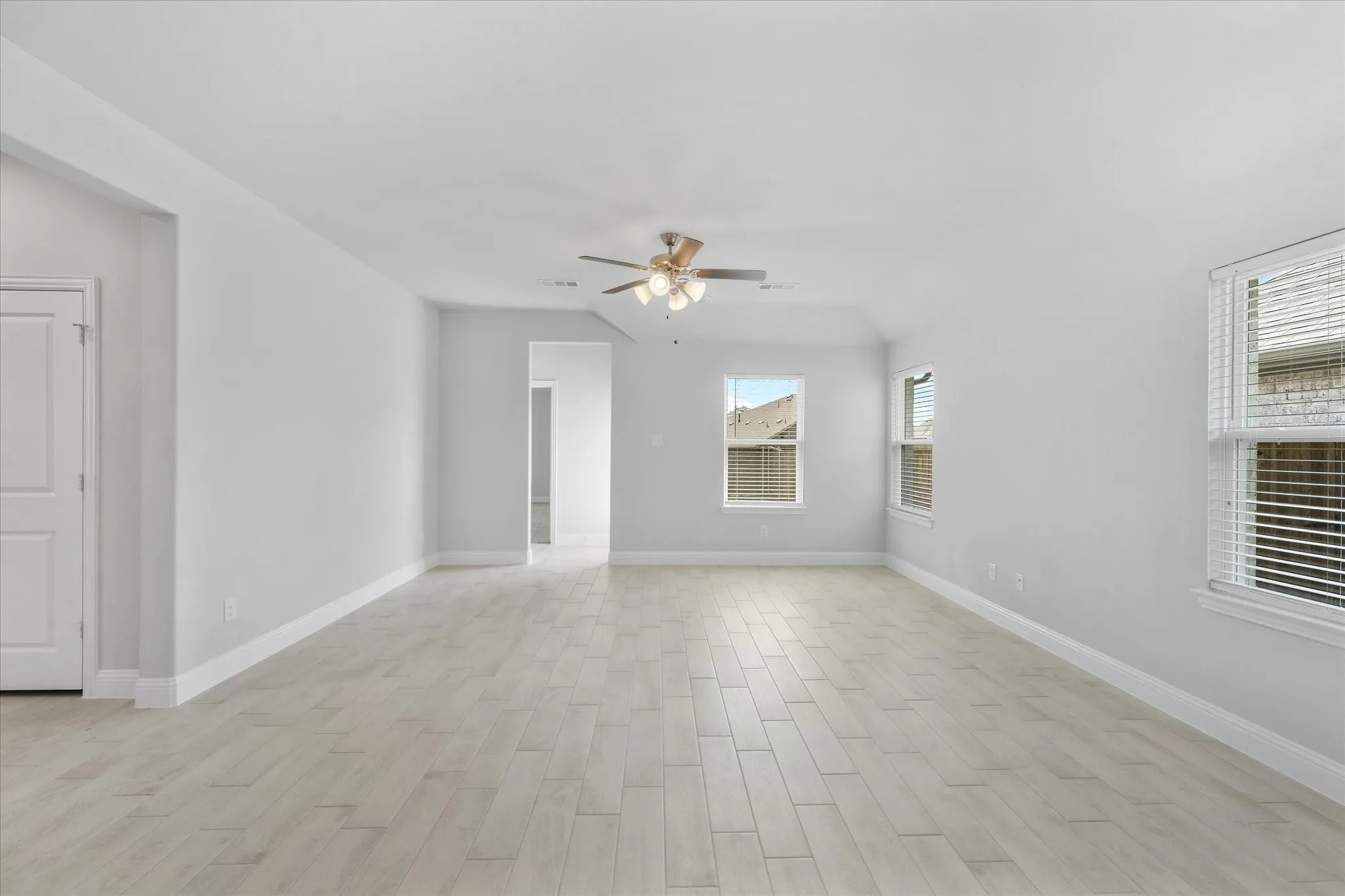 Empty room featuring plenty of natural light, light hardwood / wood-style flooring, and ceiling fan