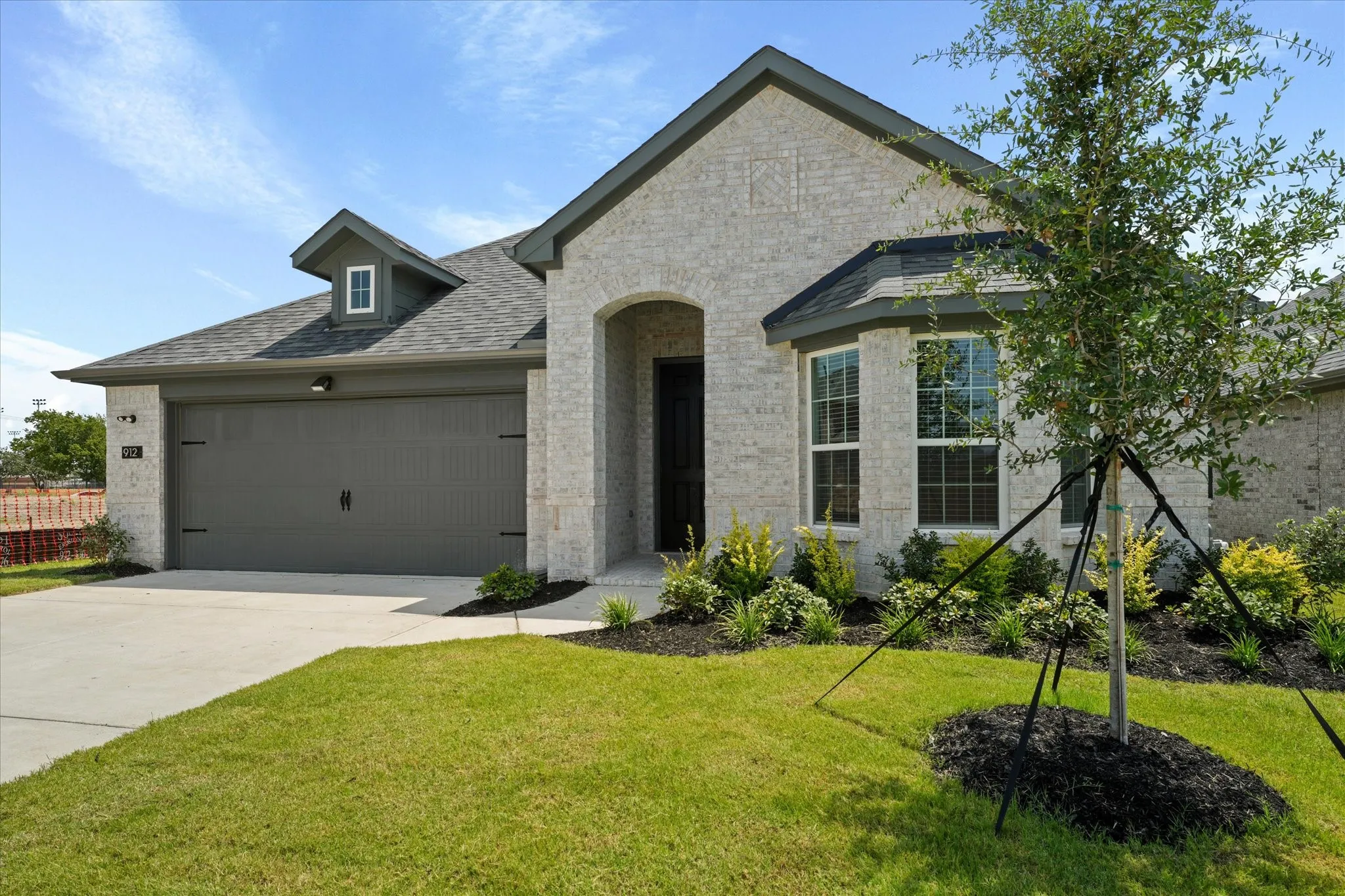 View of front of property with a garage and a front lawn