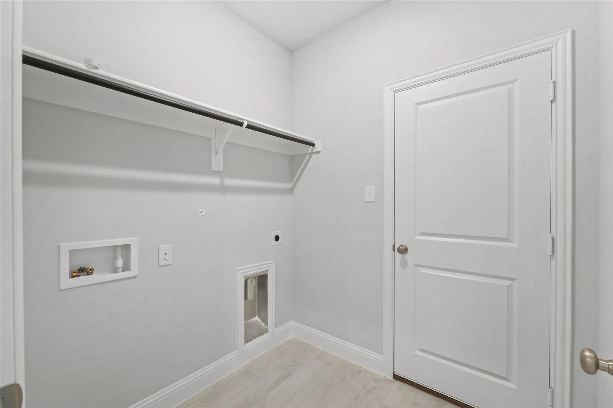 Clothes washing area featuring electric dryer hookup, gas dryer hookup, light hardwood / wood-style flooring, and hookup for a washing machine