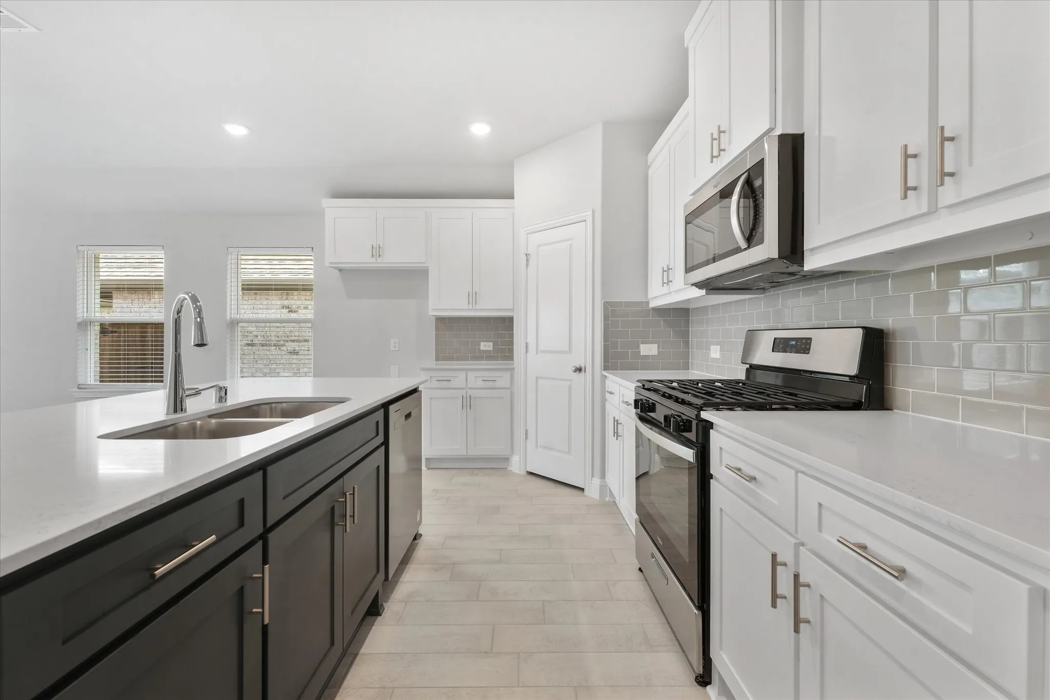 Kitchen with white cabinetry, stainless steel appliances, tasteful backsplash, and sink