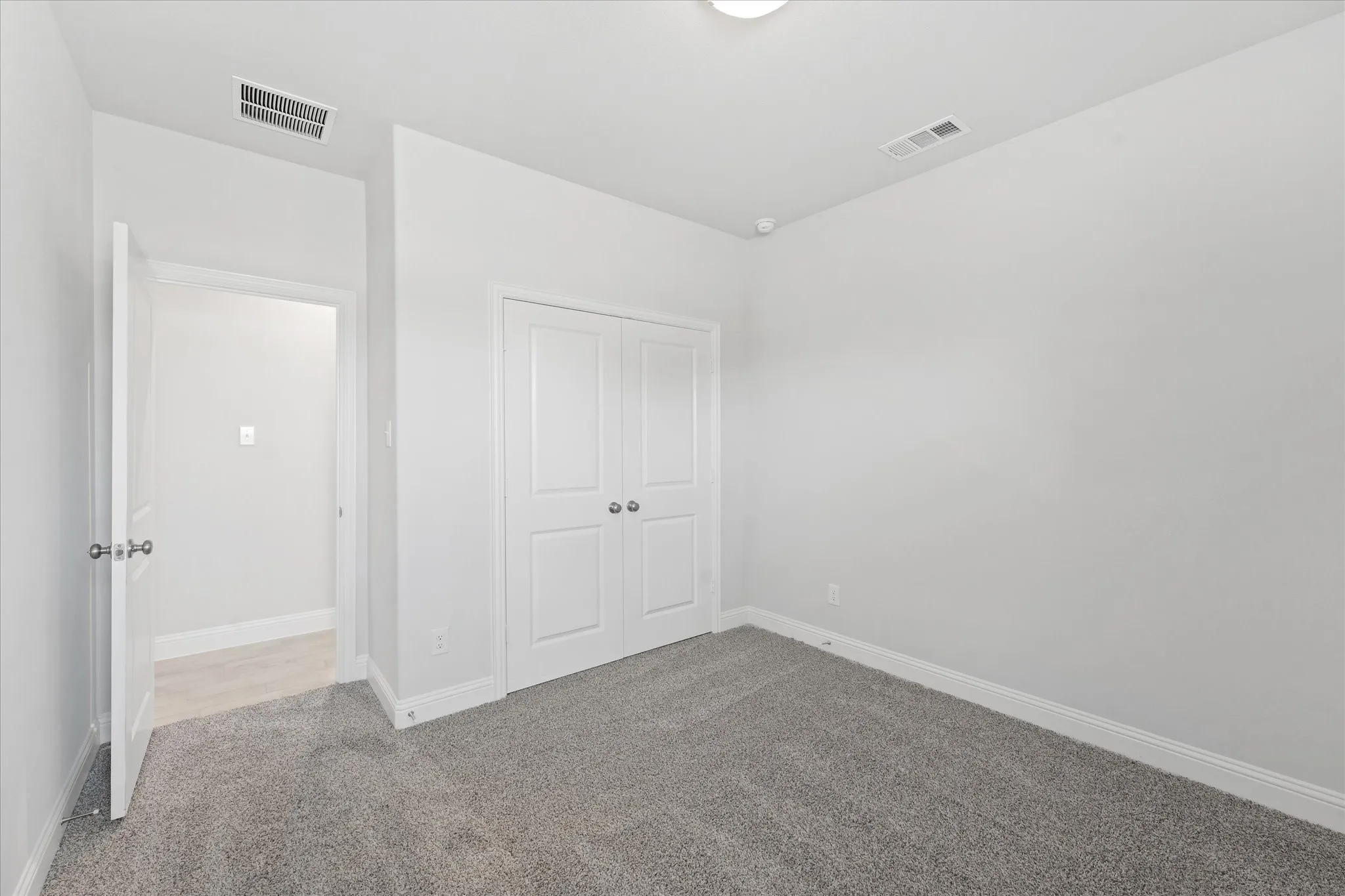 Unfurnished bedroom featuring light carpet and a closet