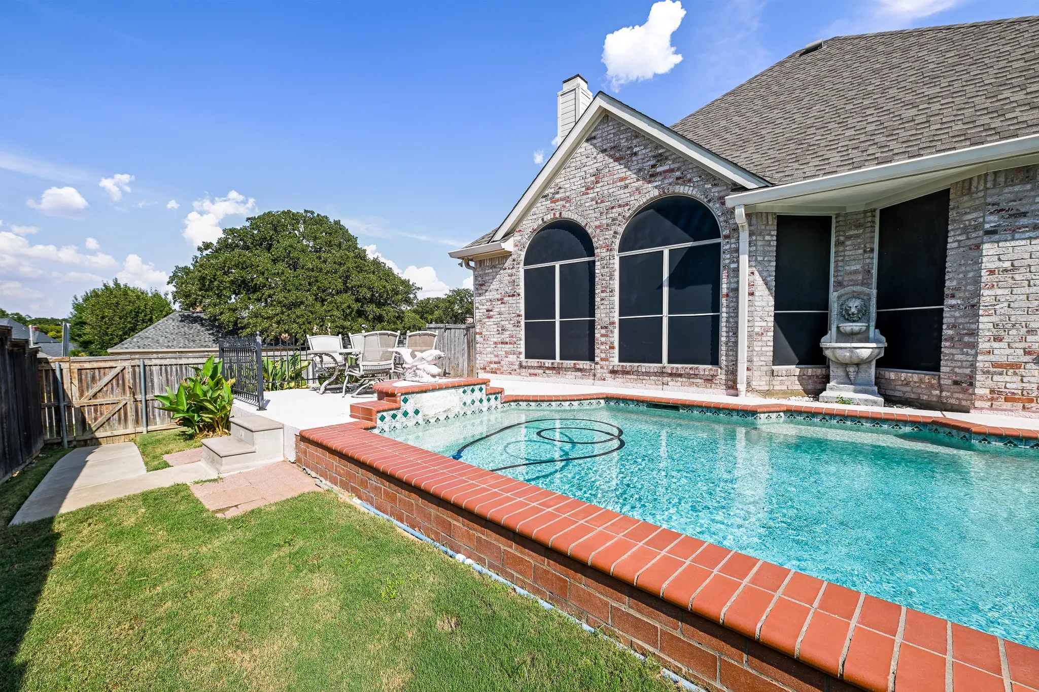 Brick exterior with an in-ground swimming pool