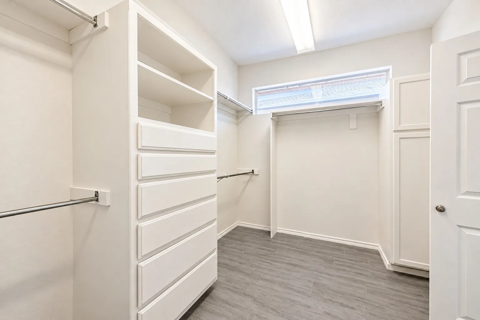 Primary Bedroom Walk-in closet featuring built-in shelving, integrated drawers, and multiple clothing rods