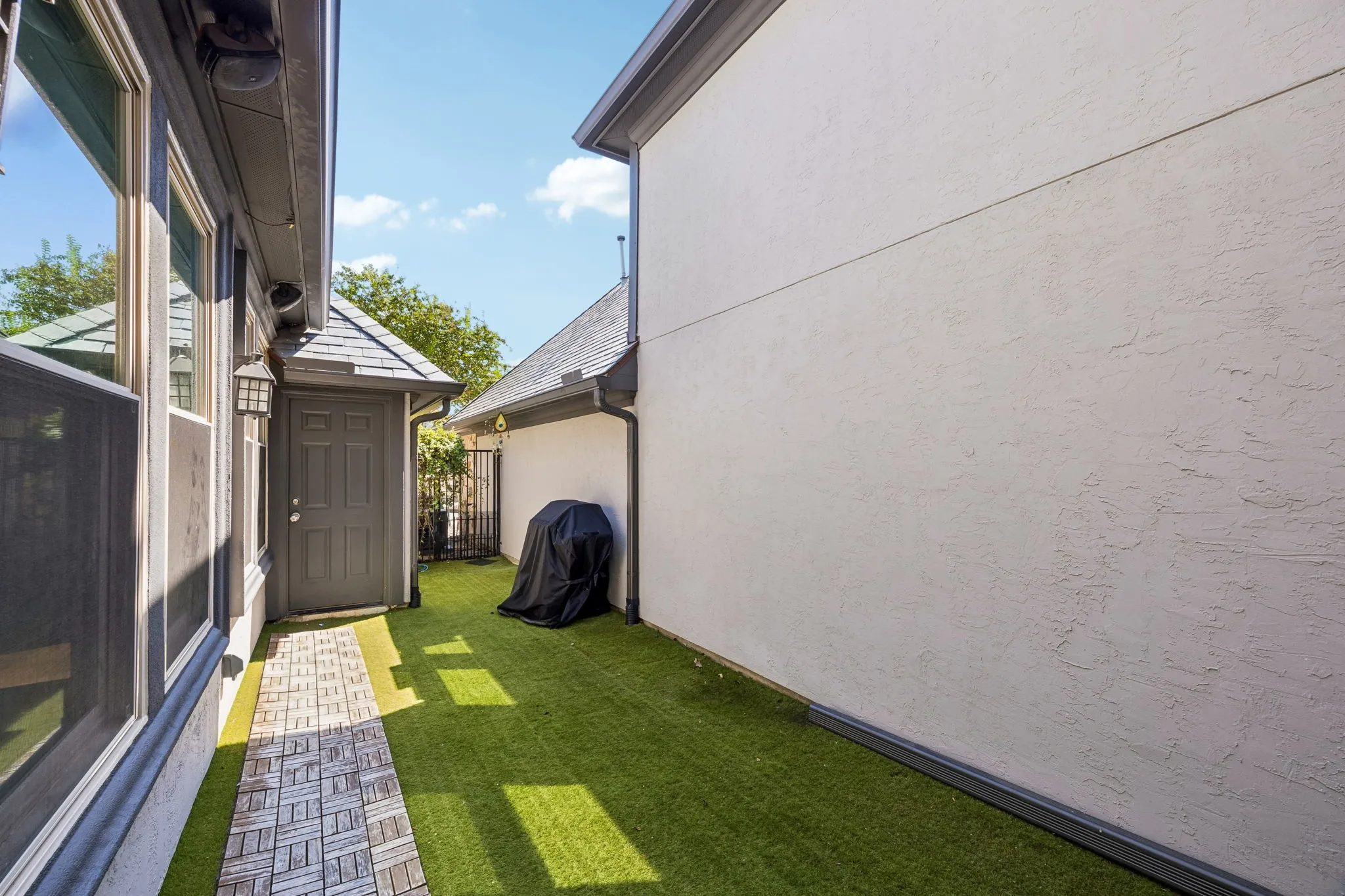 Side yard with artificial turf for low maintenance