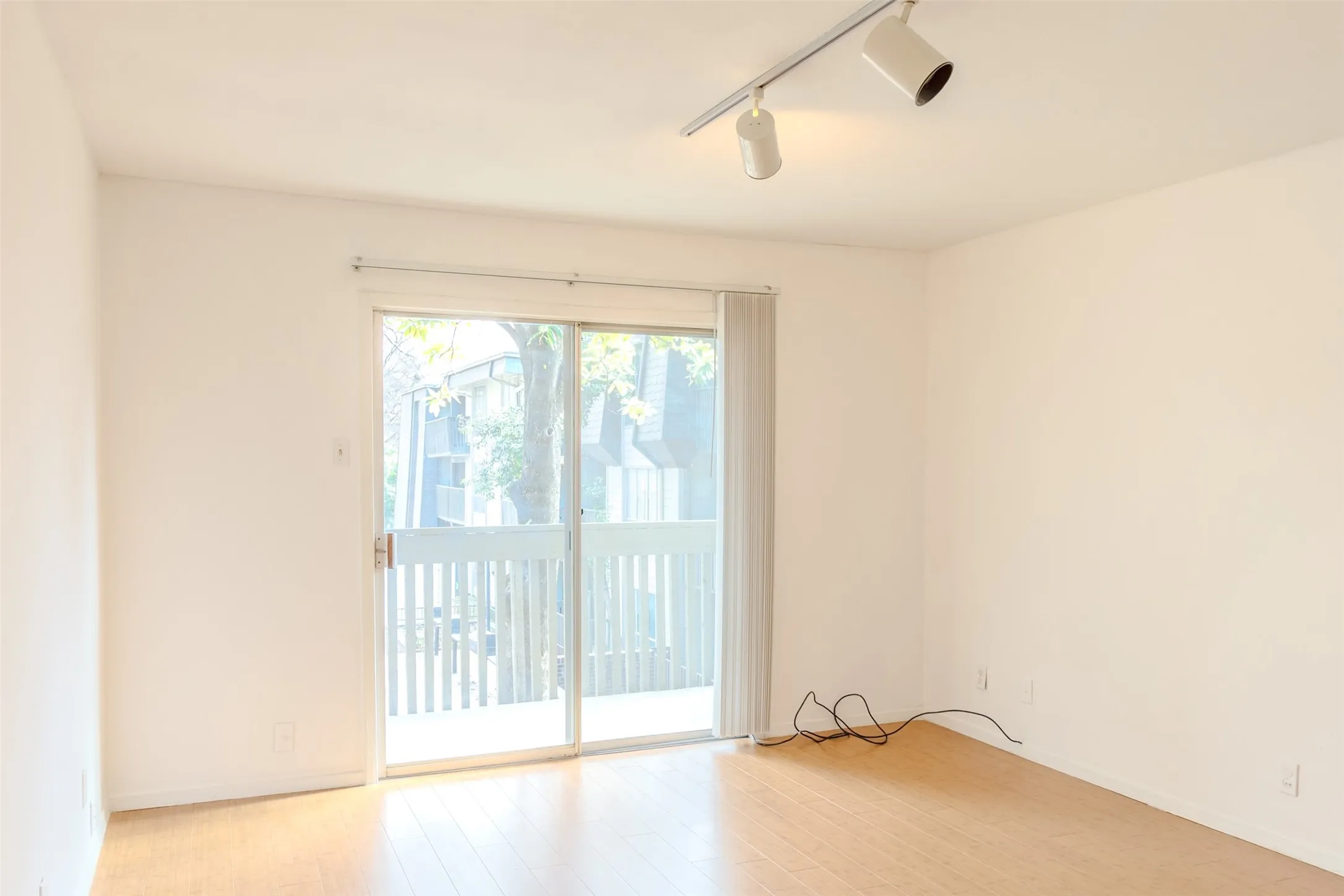 Spare room featuring track lighting and light wood-style flooring