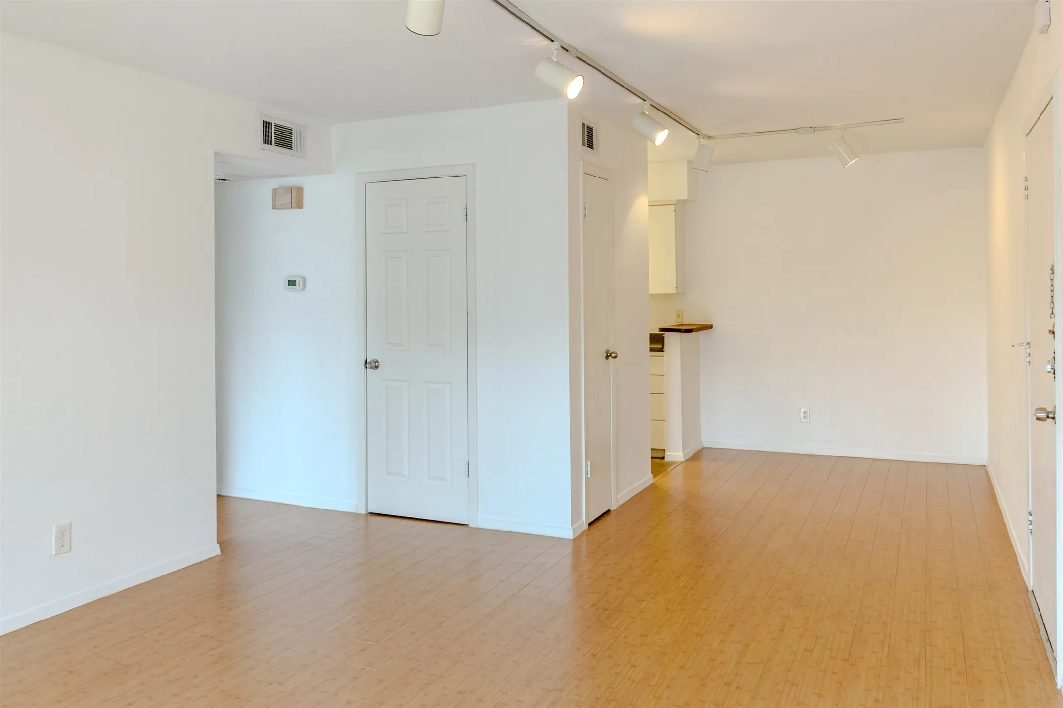 Empty room featuring track lighting and Bamboo like Laminated flooring