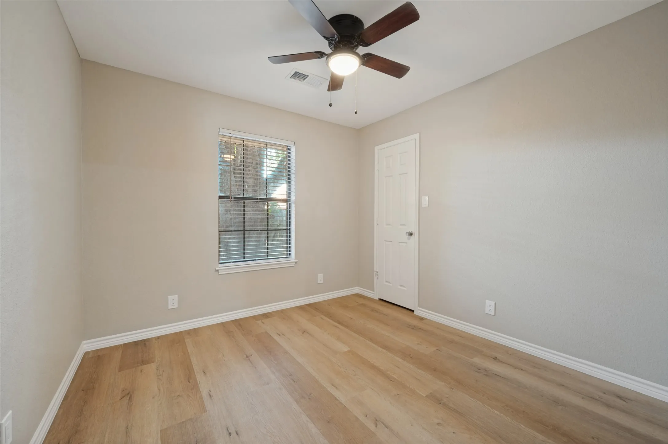 Recessed window with white blinds, LVP flooring, ceiling fan with integrated lighting, and a paneled interior door
