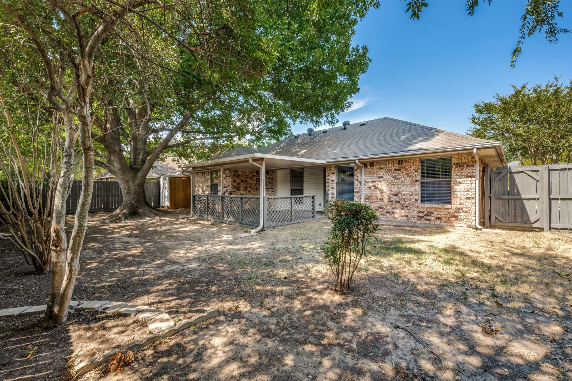 Brick exterior, covered patio, privacy fencing, mature trees