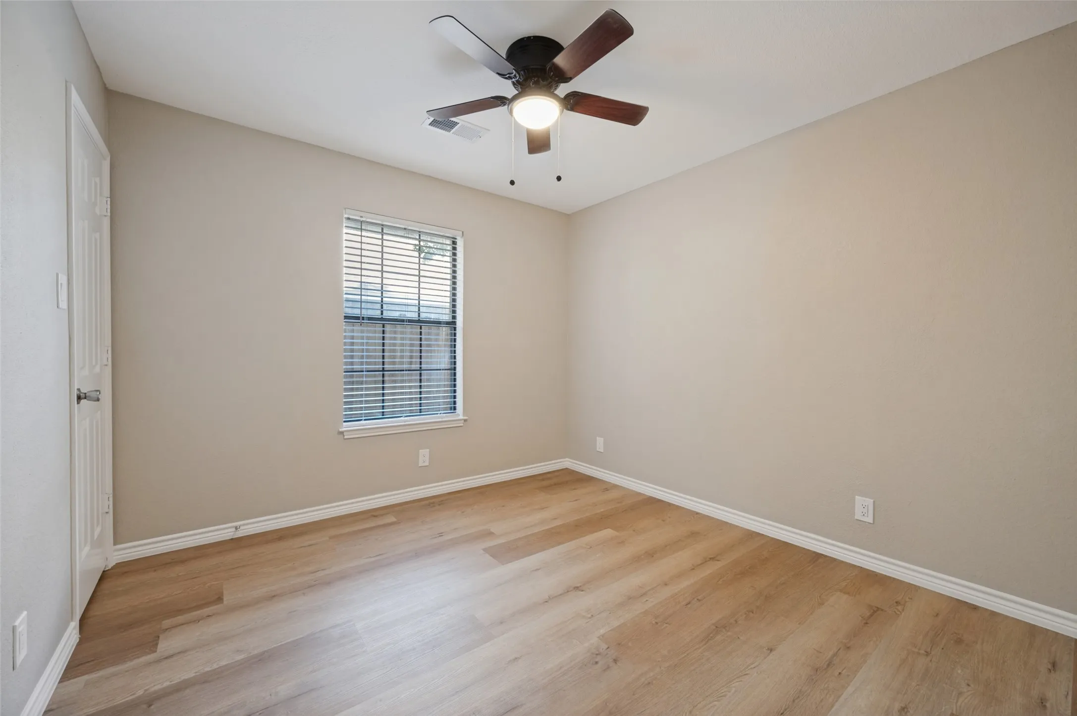 LVP flooring, ceiling fan with integrated lighting, window with blinds, and neutral-toned walls