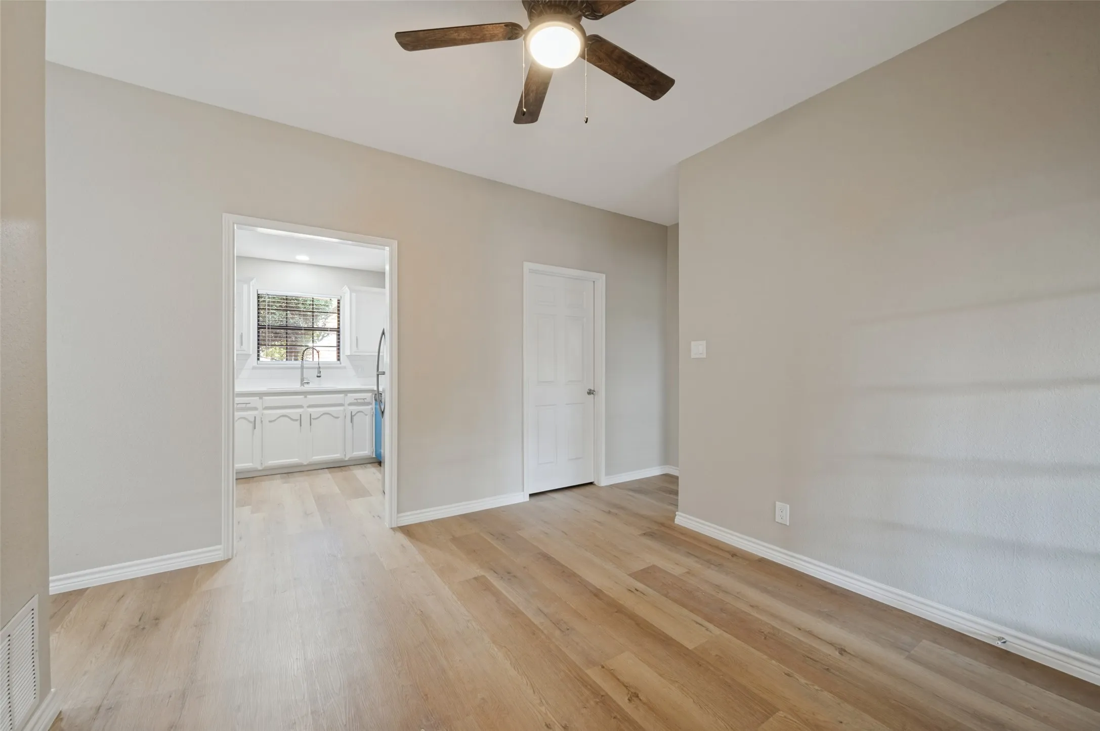 LVP flooring, ceiling fan with integrated lighting, and a neutral wall color