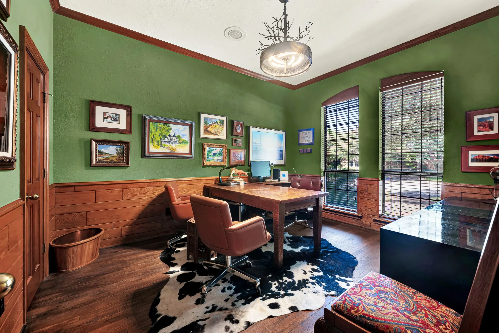 Versatile first-floor office/bedroom with rich wood paneling, hardwood floors, tall windows, and two walk-in closets.