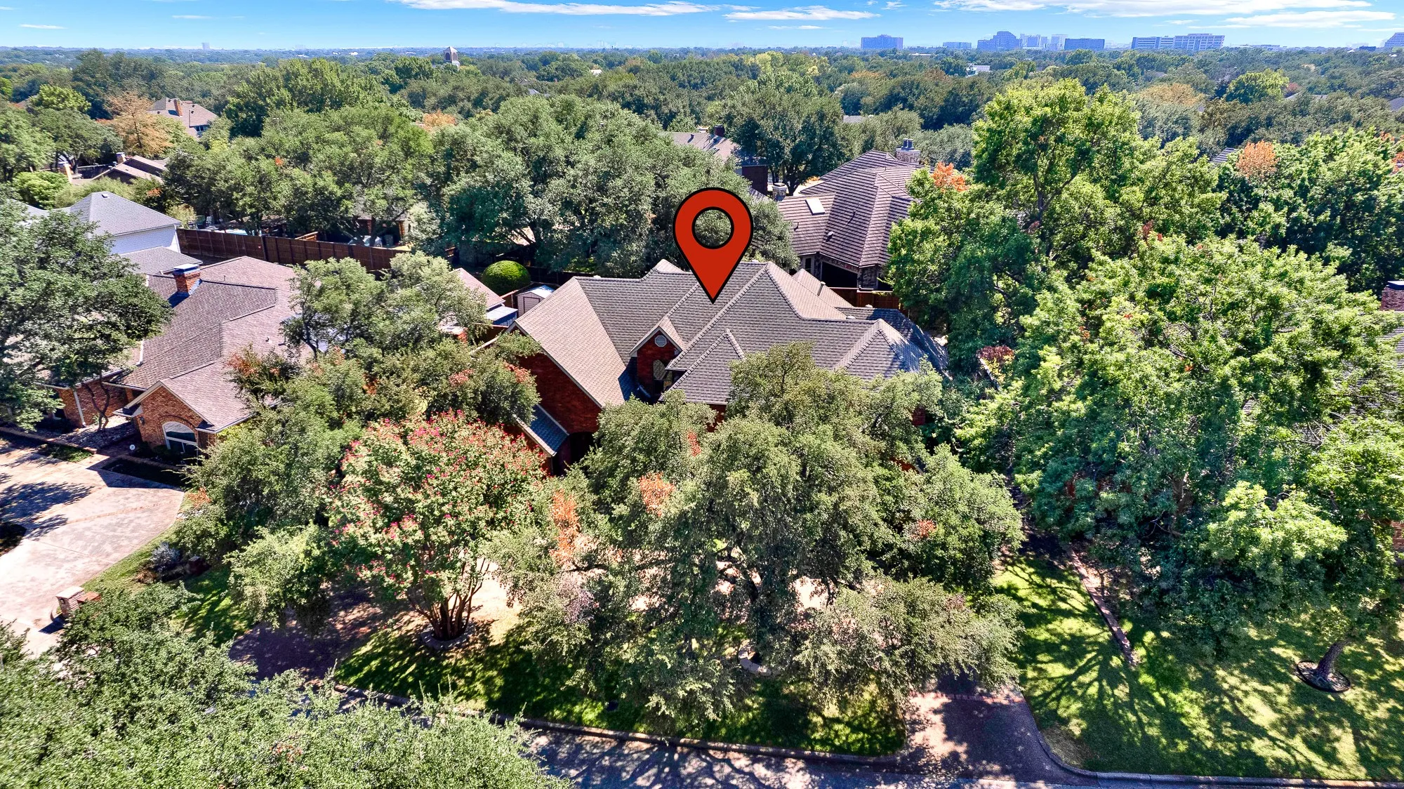Drone image view from front of property on Briargrove Lane. Mature trees at street and left side of home.