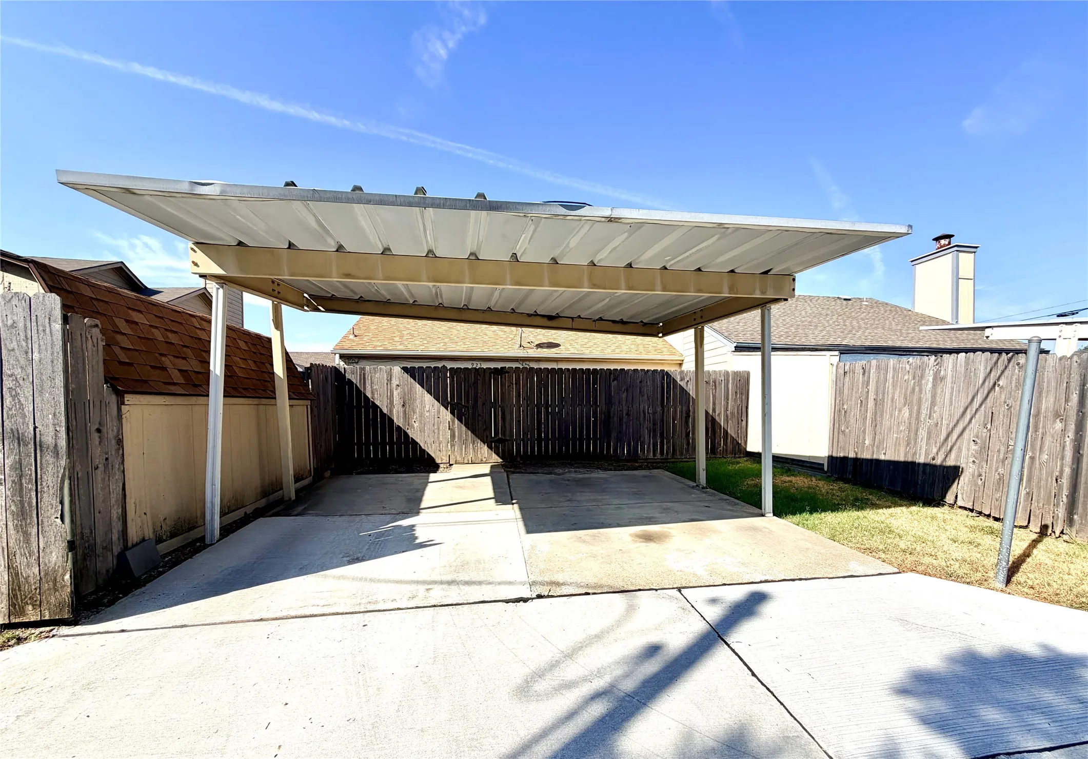 Concrete driveway leading to a covered carport