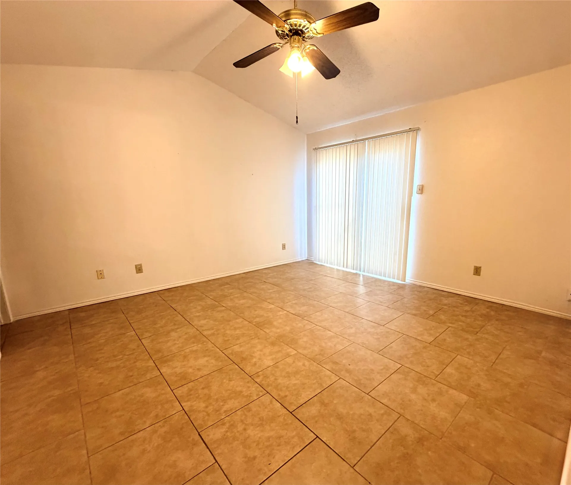 Vaulted ceiling with a ceiling fan, neutral wall tones, tile flooring, and sliding glass door with vertical blinds